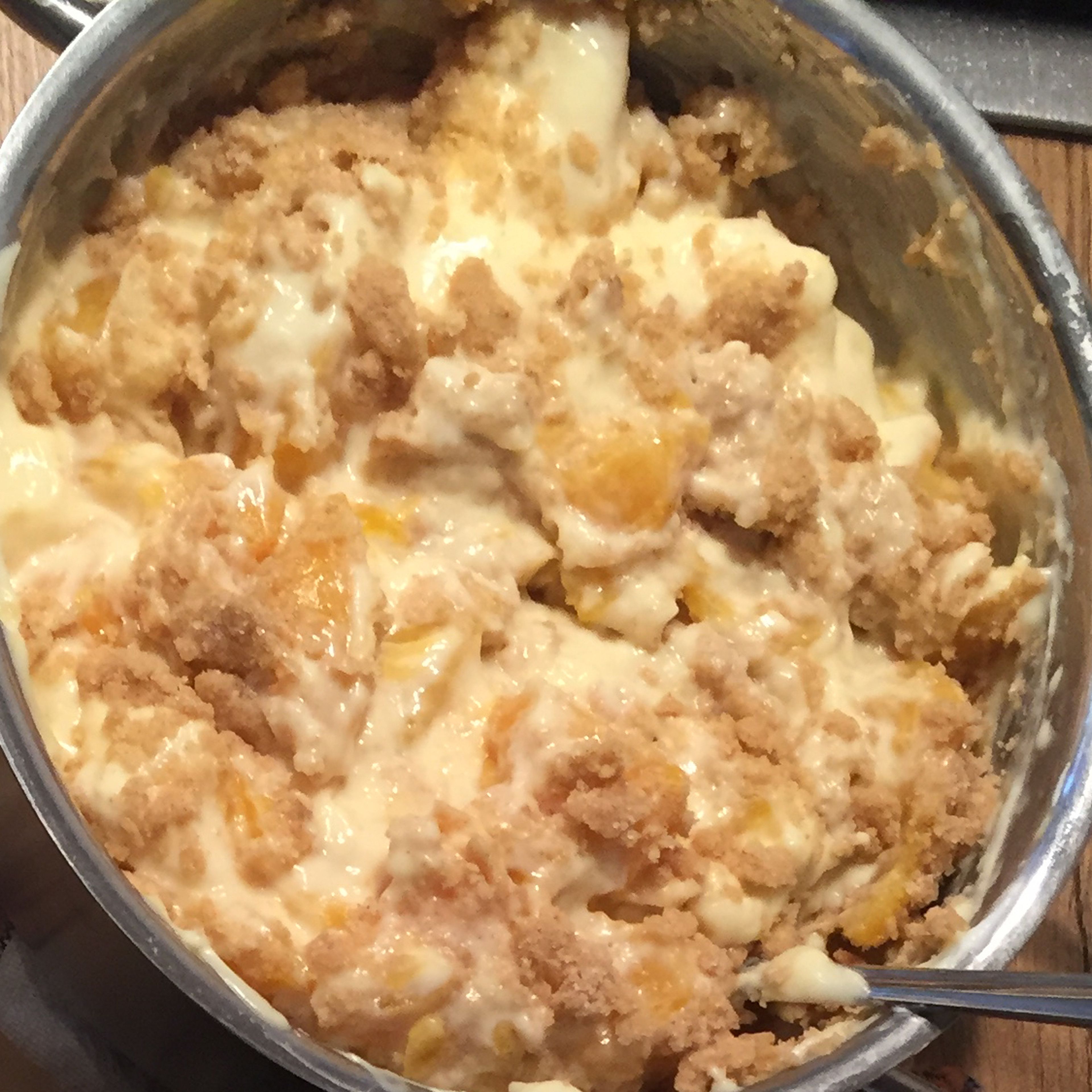 Die Pfirsiche in kleine, mundgerechte Stücke schneiden und mit dem Quark in die Puddingmasse einrühren.