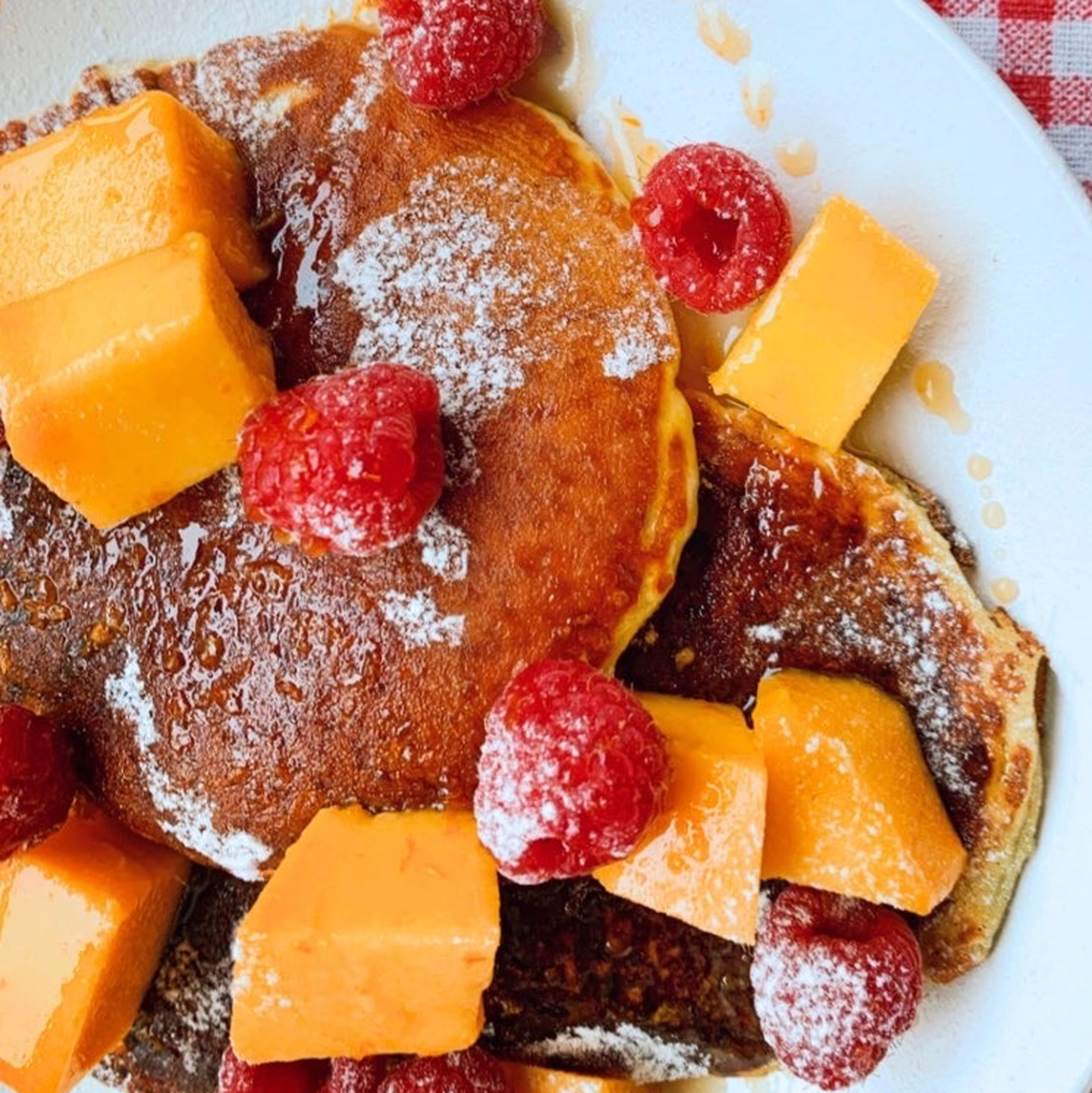 Plate the pancakes and top with fresh fruits. Lightly dust with flour and serve with the syrup as poured right before eating to prevent sogginess.