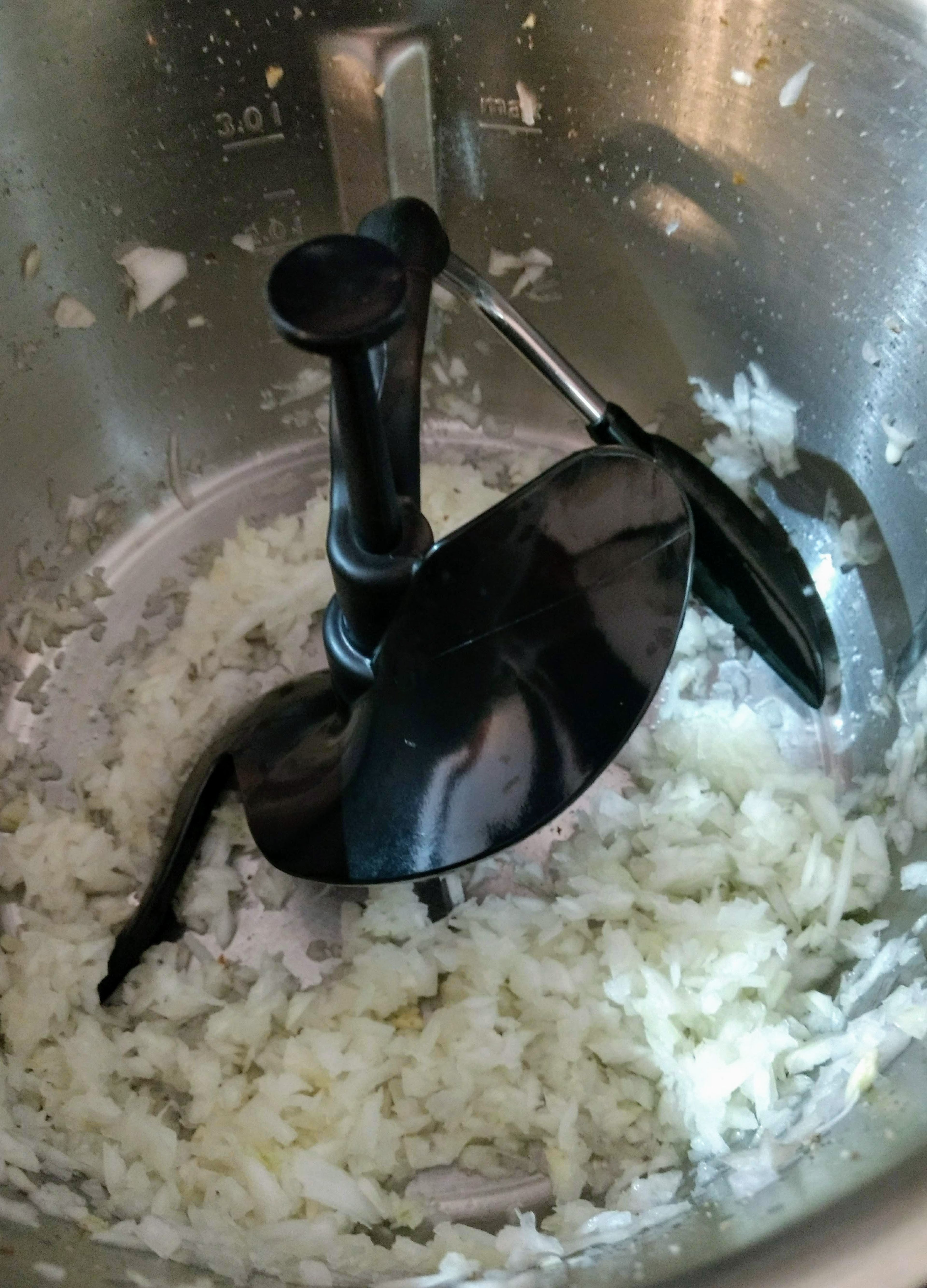 3D- Rührer einsetzen. 50 g Butter in den Topf wiegen, Deckel ohne Messbecher schließen und die Zwiebelwürfel glasig anschwitzen (3D-Rührer | Stufe 4 | 60 °C | 2 Min. 30 Sek.).