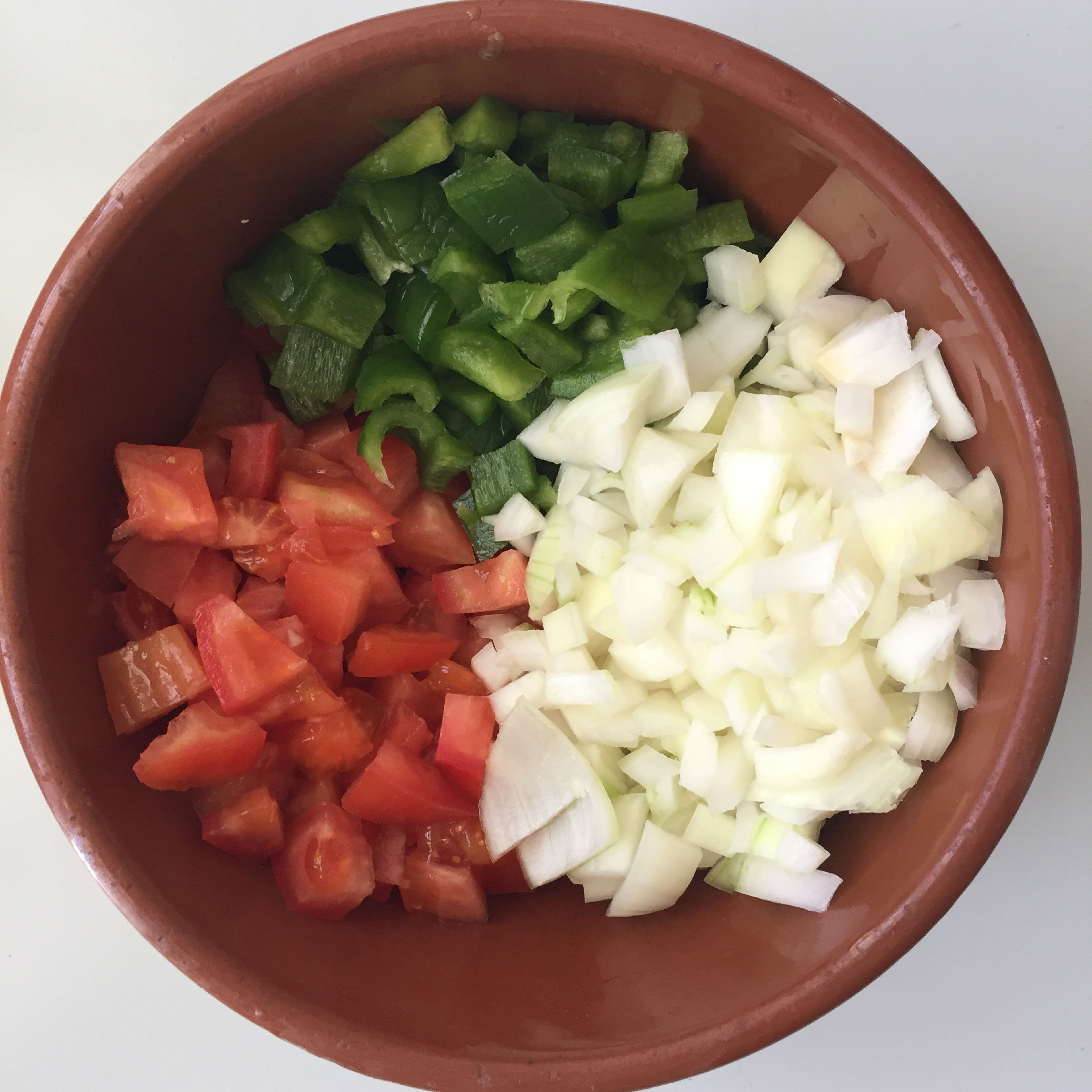 Chop onion, tomatoes and green bell pepper. Red bell pepper would also work fine, but the green enhaces the colors of the salad. 