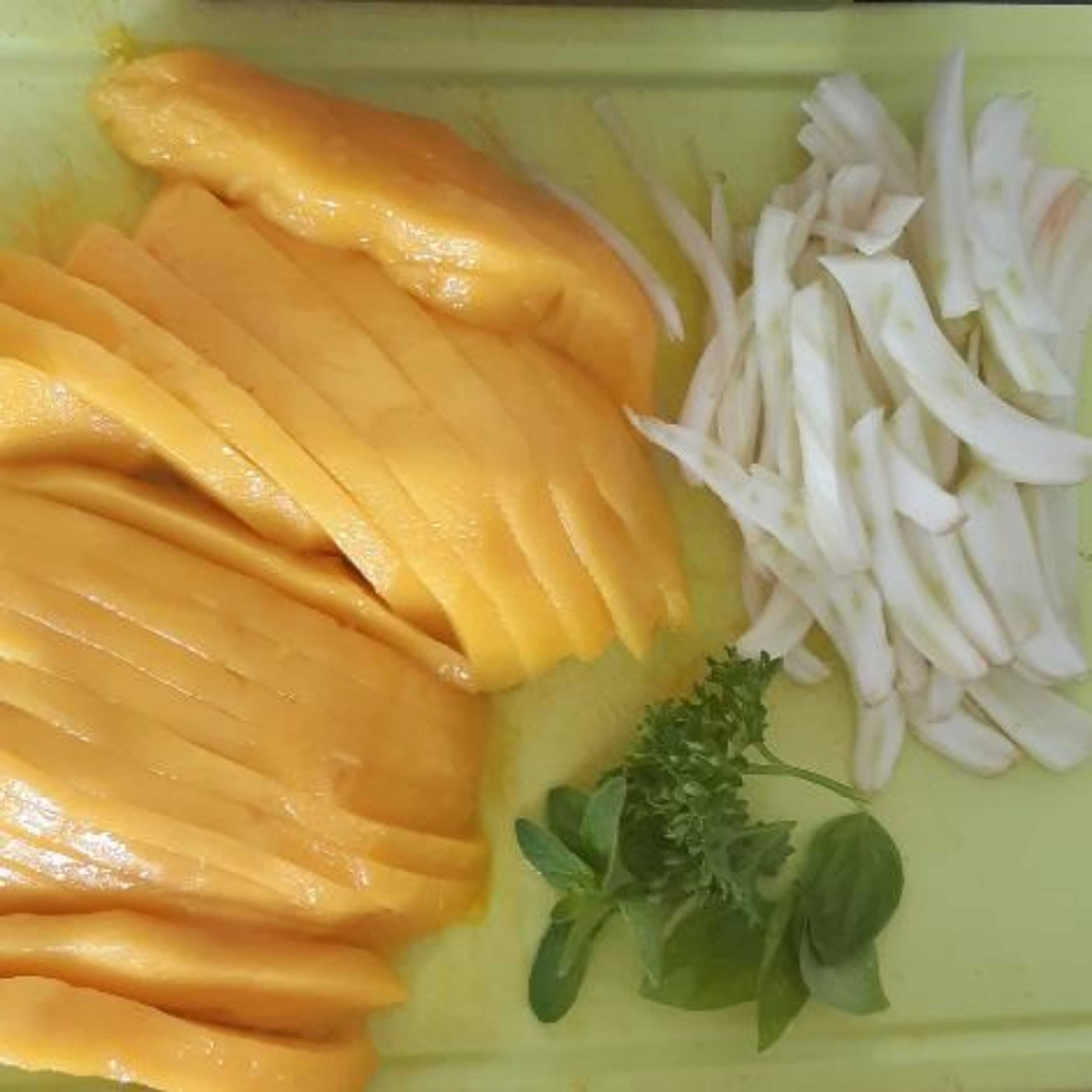 Mango und Fenchel in Streifen schneiden. Die Mangostreifen in einer beschichteten Pfanne ohne Öl anbraten und Pfeffern.