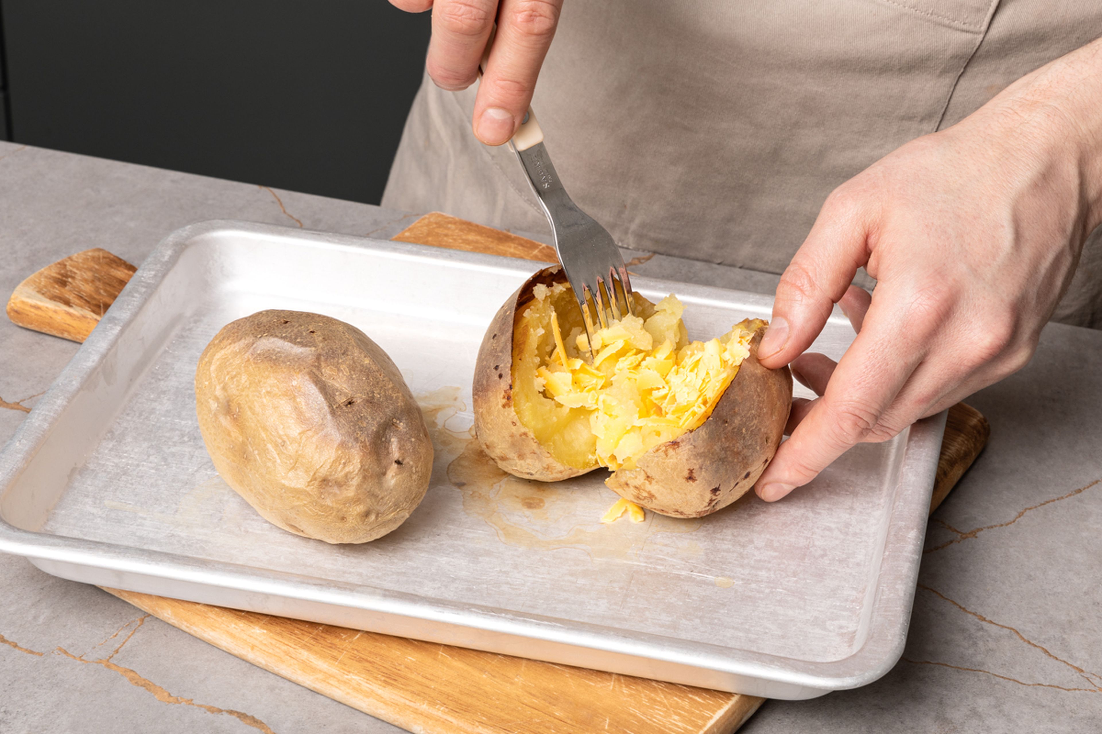 Wenn die Kartoffeln gebacken sind, aus dem Ofen nehmen und mit einem Messer in der Mitte leicht aufschneiden. Cheddar-Käse hineingeben und das Innere mit einer Gabel ein wenig auflockern. Fülle die Kartoffel nun großzügig mit den Bohnen. Dann mit saurer Sahne und Frühlingszwiebelringen und eventuell einigen Chilischeiben garnieren. Guten Appetit!