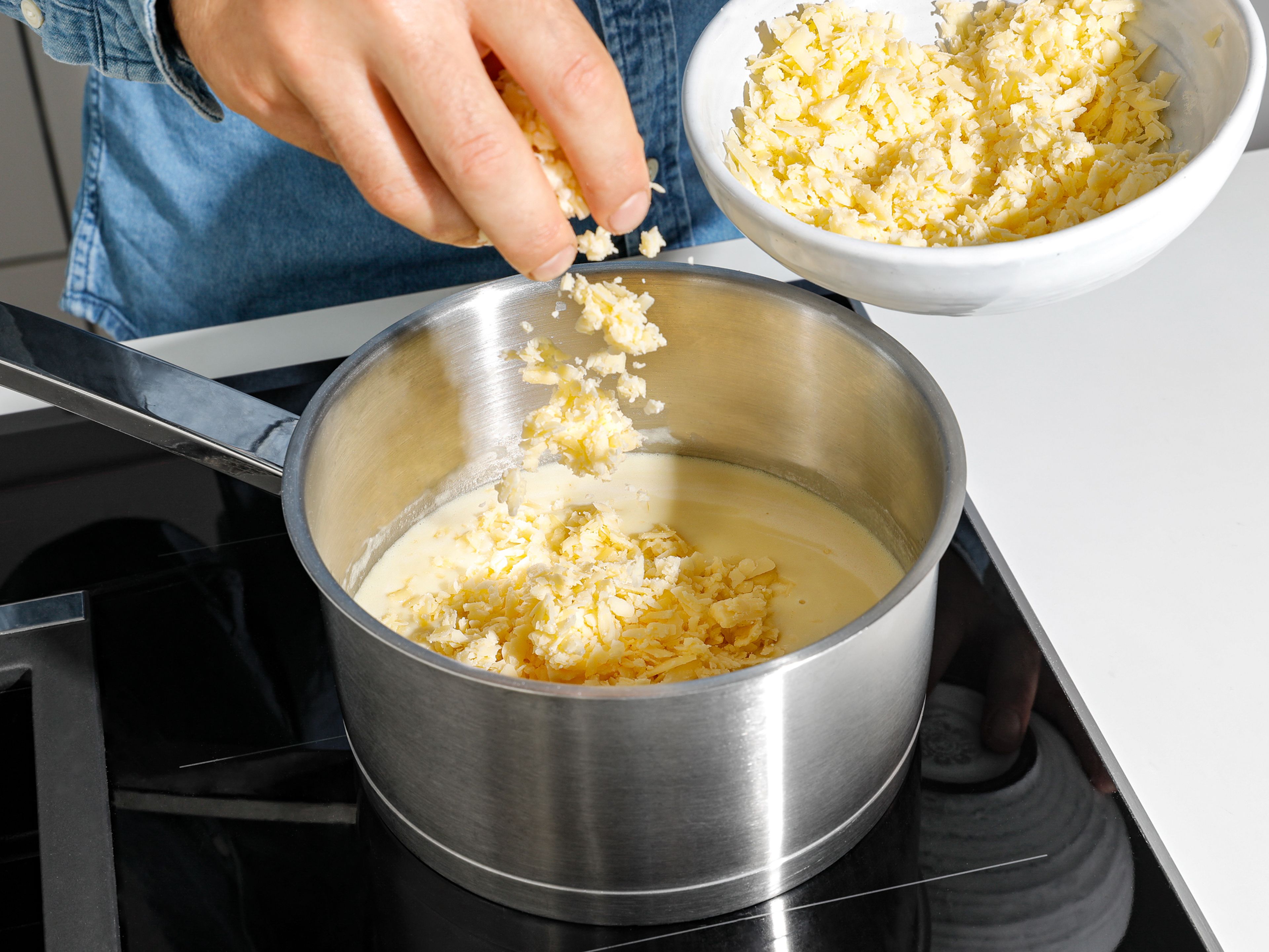 In der Zwischenzeit den Bier-Käse-Dip zubereiten. Butter in einem Stieltopf schmelzen und Mehl einrühren. Unter Rühren Milch und Flensburger Pilsener dazugeben und verrühren, bis eine glatte Mischung entsteht. Dijonsenf und geriebenen Cheddarkäse einrühren und den Dip mit Salz und Pfeffer abschmecken. Warmen Käsedip zu den Brezel-Bites servieren. Guten Appetit!