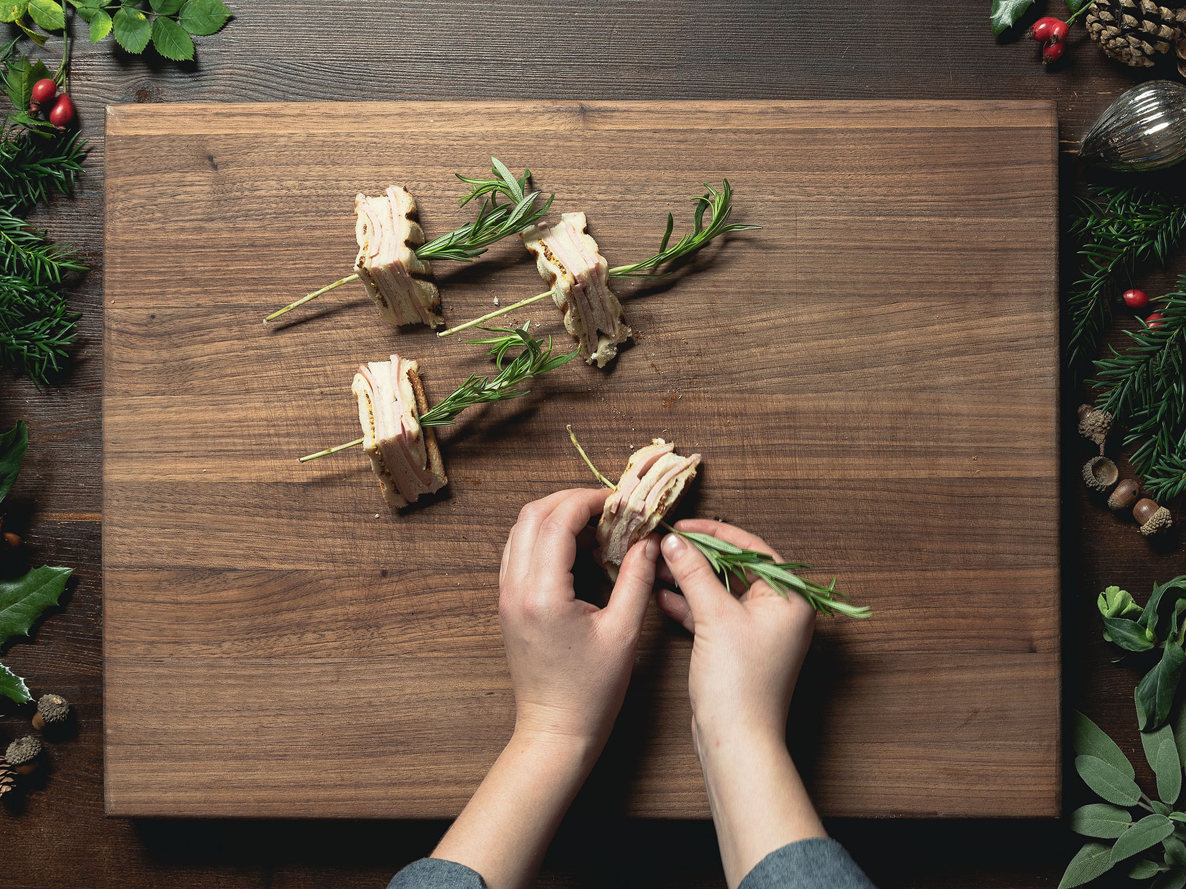 Cut each sandwich into four triangles and halve each rosemary sprig width-wise. Skewer each sandwich triangle on one rosemary sprig. Enjoy as an appetizer!