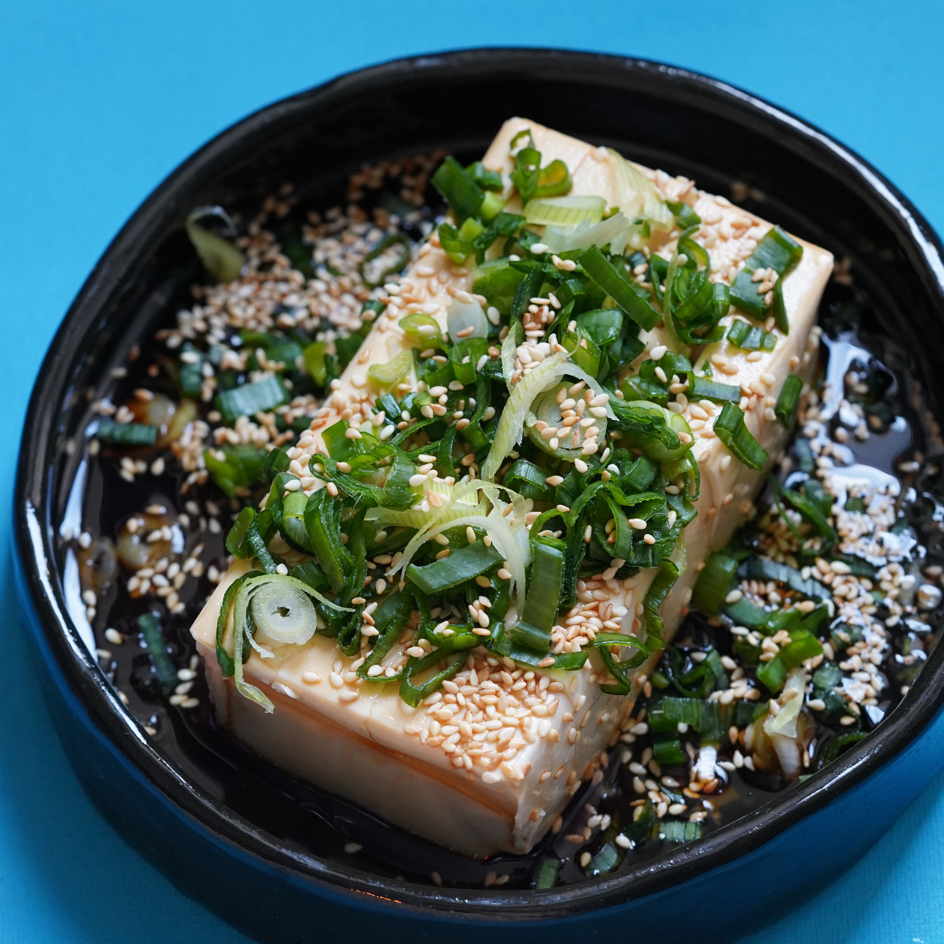 Pour the sauce over your tofu! Now lay the chives on top and sprinkle generously with sesame seeds.