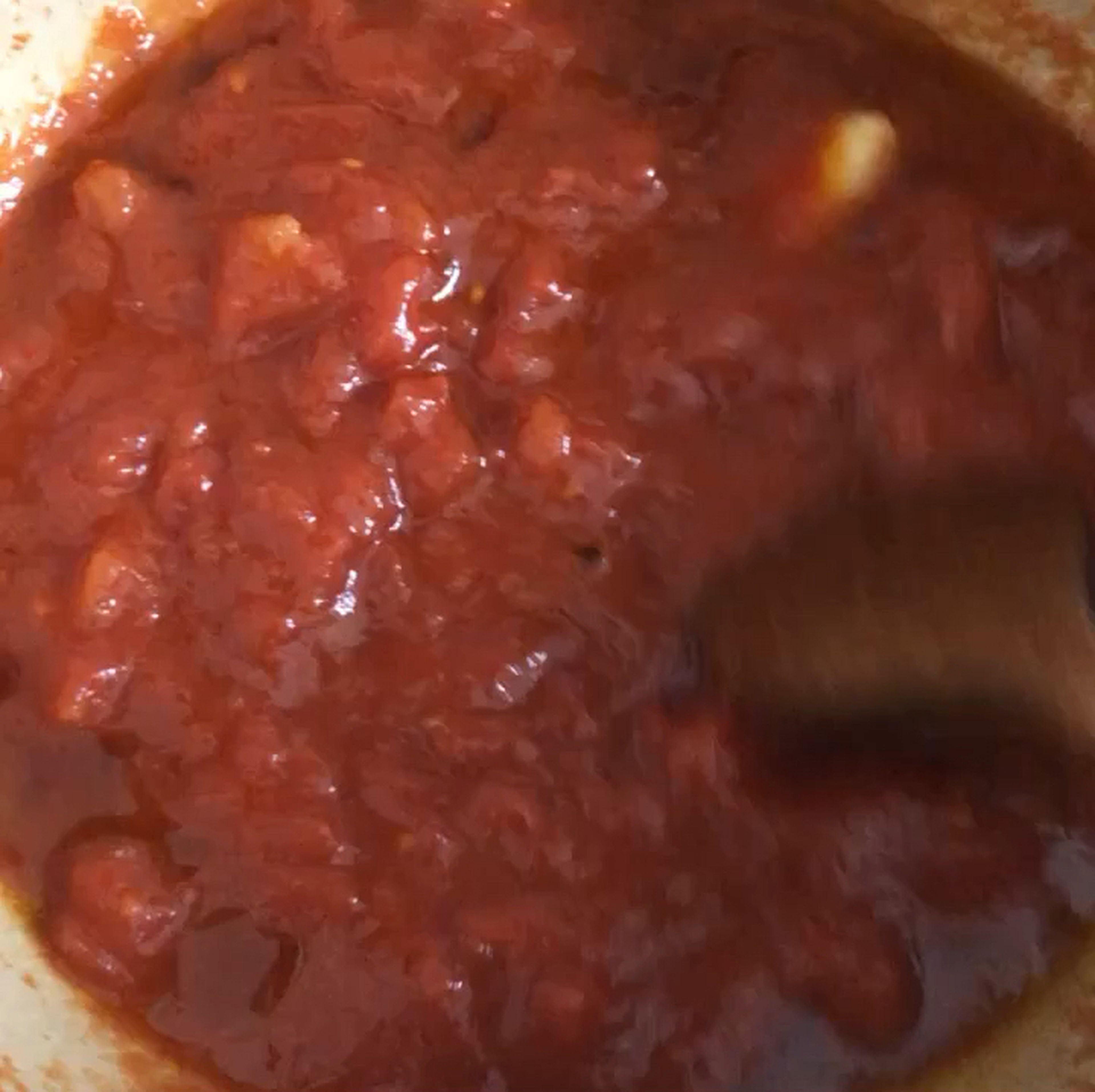 Sobald sich die Sardellen größtenteils im Olivenöl aufgelöst haben, die Knoblauchzehe, Tomaten aus der Dose und eine kräftige Prise Salz hinzugeben. Alles gut miteinander vermengen und bei geringer Hitze unter gelegentlichem Rühren ca. 15 Min. köcheln lassen. (Wenn die Soße viel spritzt, einfach leicht abdecken.) Vor dem Servieren mit mehr Salz und Pfeffer abschmecken. (Für eine cremigere Soße vor dem Servieren pürieren.)