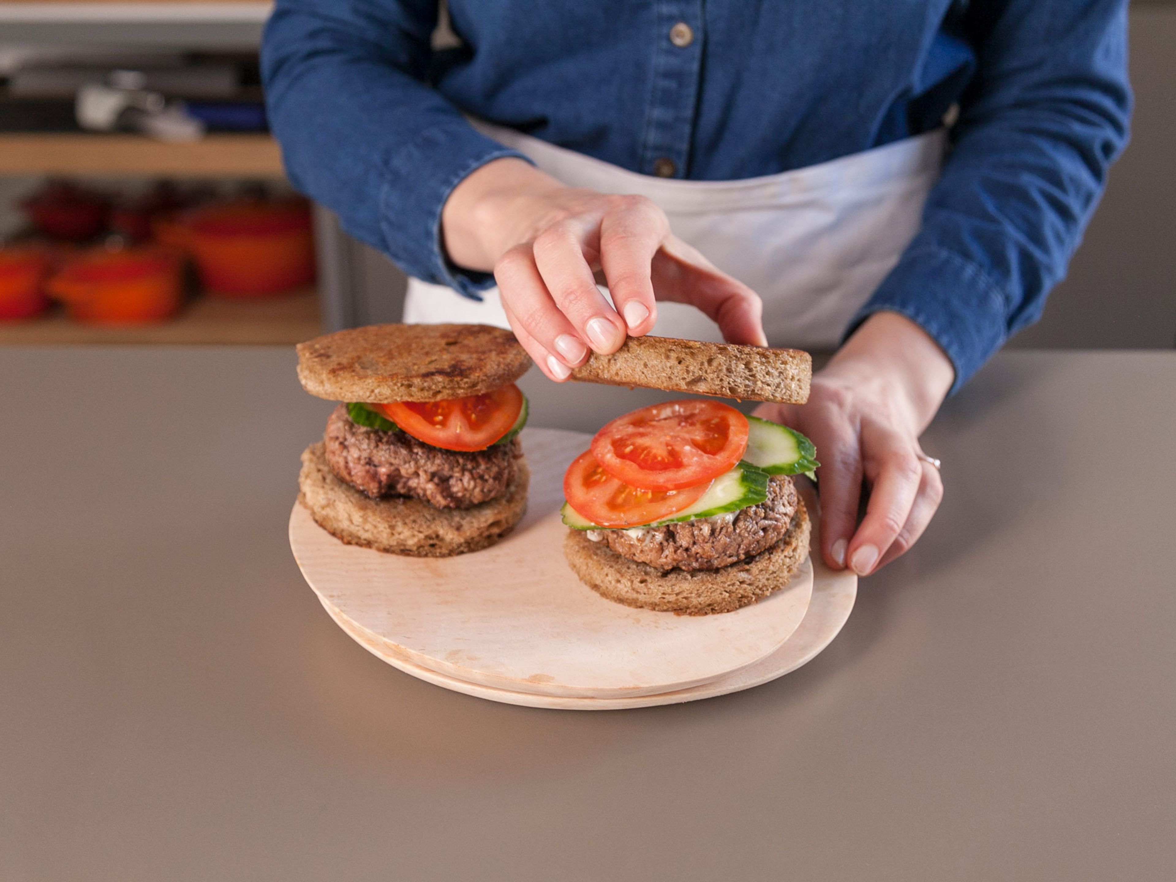Top rye bread slices with mayonnaise, burger patties, and slices of tomato and cucumber. Enjoy!