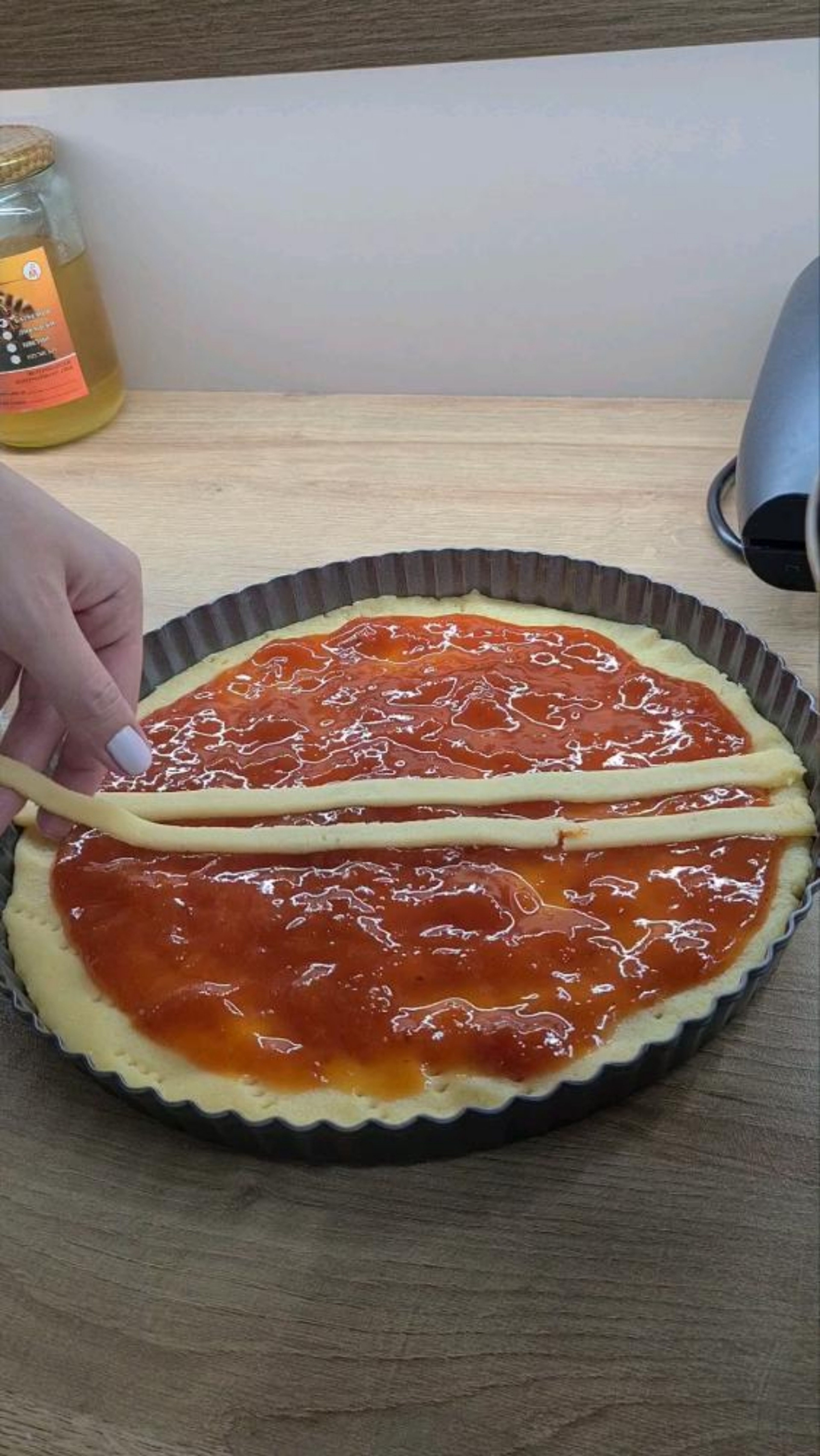 Shape the bottom and prick it with a fork, add jam, and from the rest of the dough make decorations for around and in the middle as desired.