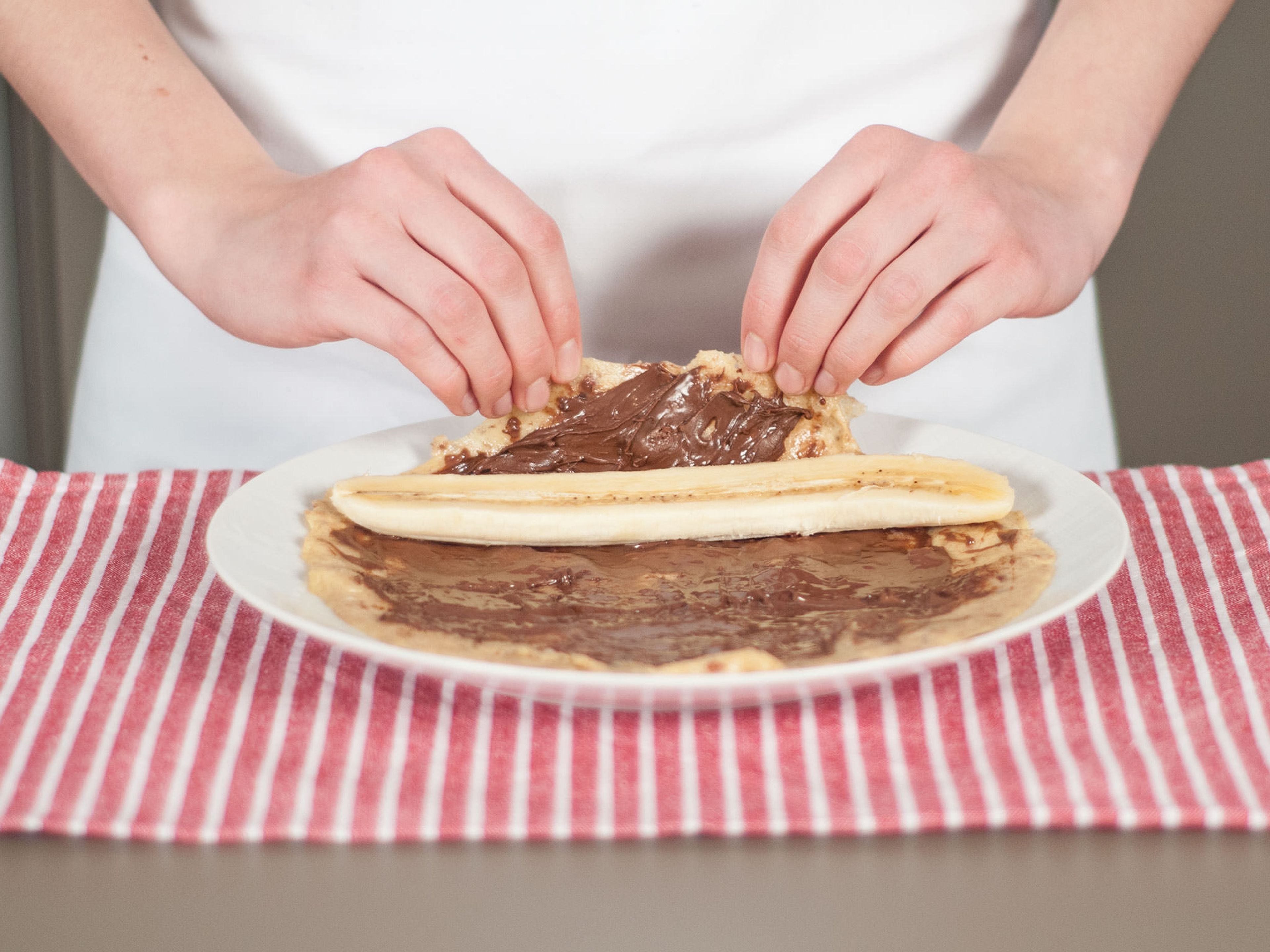 Spread a thin layer of hazelnut spread over each pancake. Place a banana slice on top and roll the pancake up. Enjoy with confectioner’s sugar, if desired.