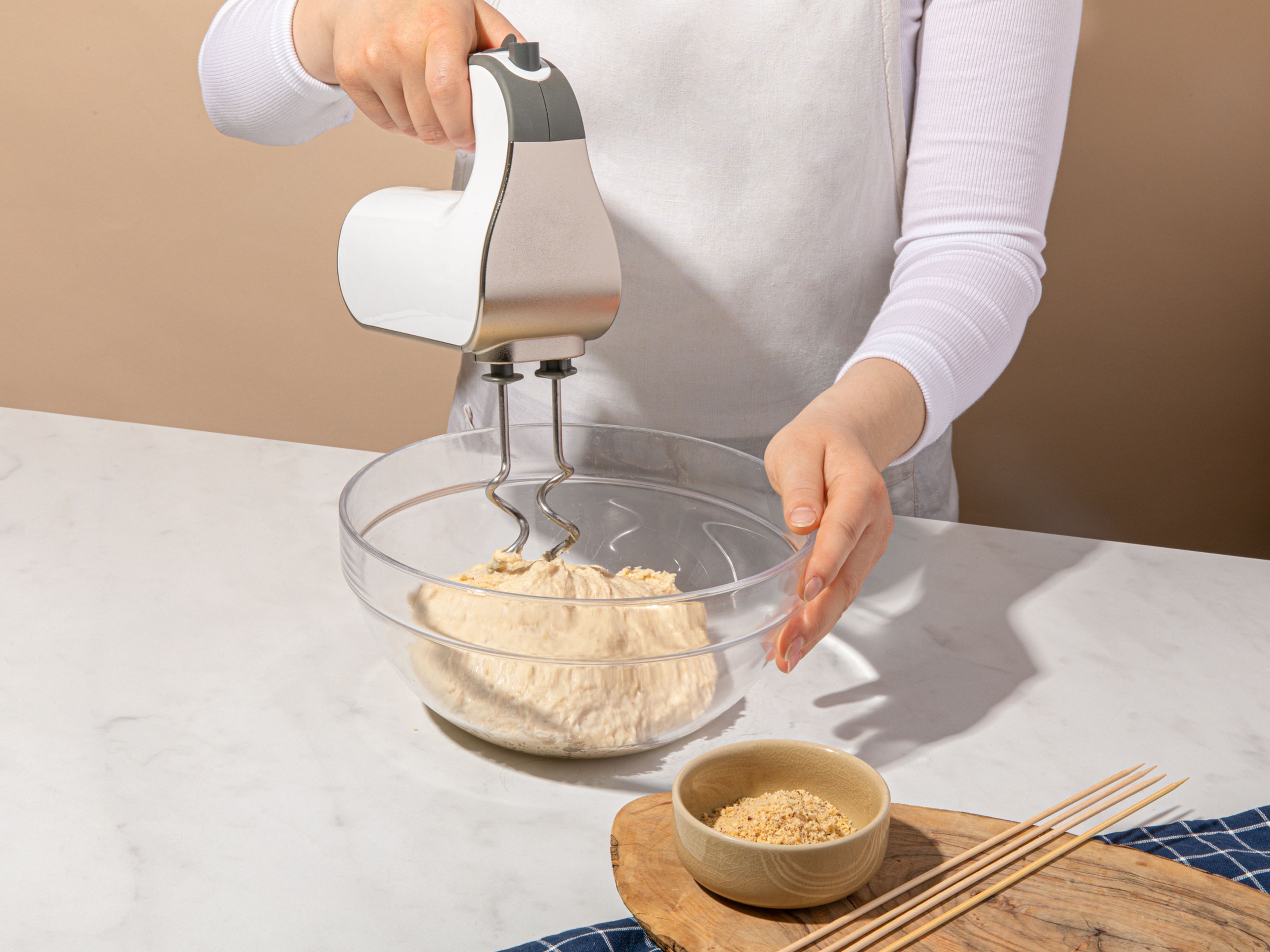Mehl mit 50 g gemahlenen Haselnüssen, Trockenhefe, Salz und Zucker mischen. Dann mit der Milch und dem Öl in der Küchenmaschine zu einem geschmeidigen Teig kneten. Der Teig sollte sich vom Schüsselrand lösen und schön weich und glänzend sein. Aus der Schüssel nehmen, mit den Händen weiter kneten und zu einer Kugel formen. Wieder in die Schüssel geben, mit einem Geschirrtuch abdecken und für 1h gehen lassen.