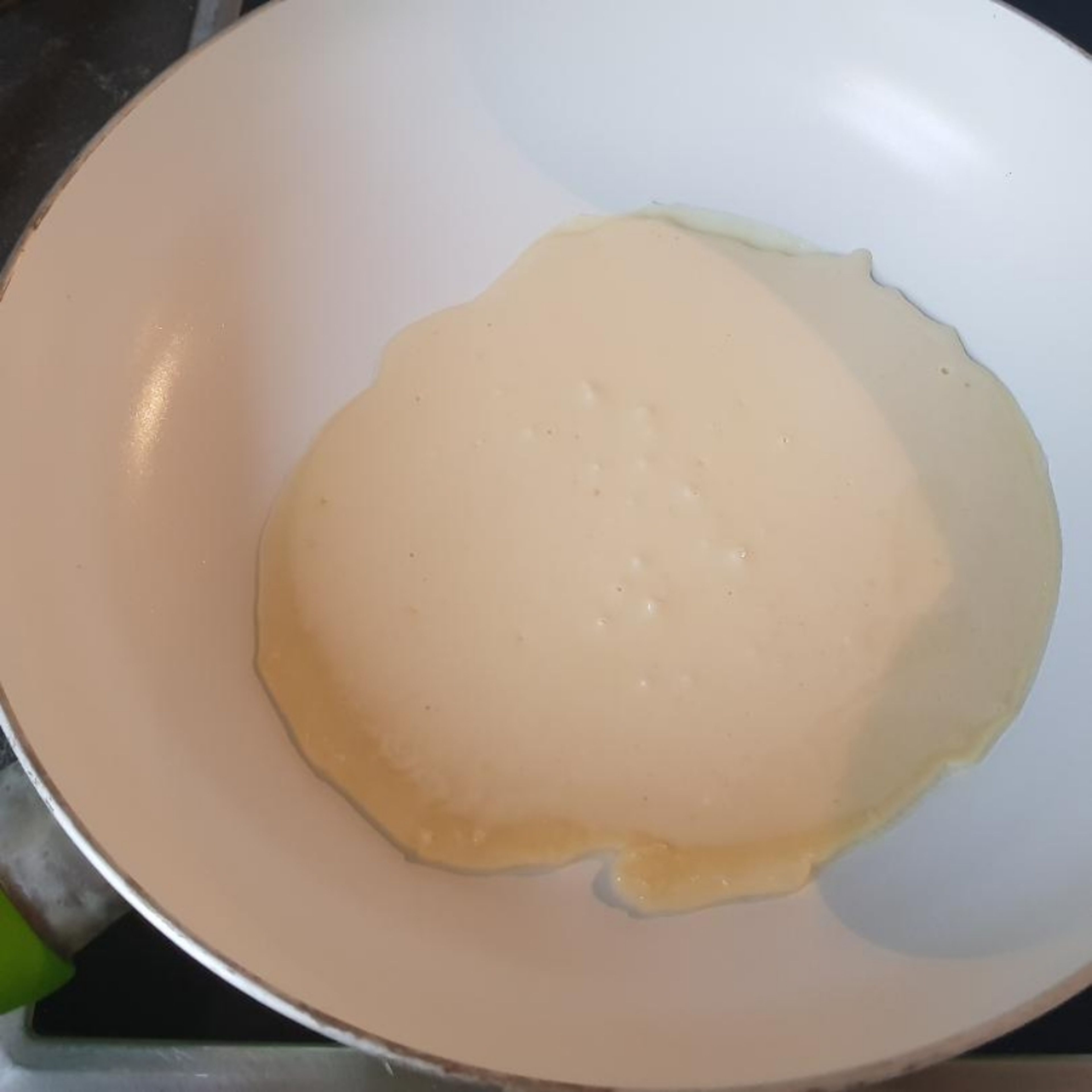 Schritt 4 : Sobald die Pfanne erhitzt ist den Teig mit einer Kelle von links oben eingießen und warten bis die Oberfläche des Pfannekuchens hart ist , dann wenden . Wenn der Pfannkuchen von beiden Seiten goldbraun ist und nicht klebt kann man ihn hinunternehmen und weiter machen 😋