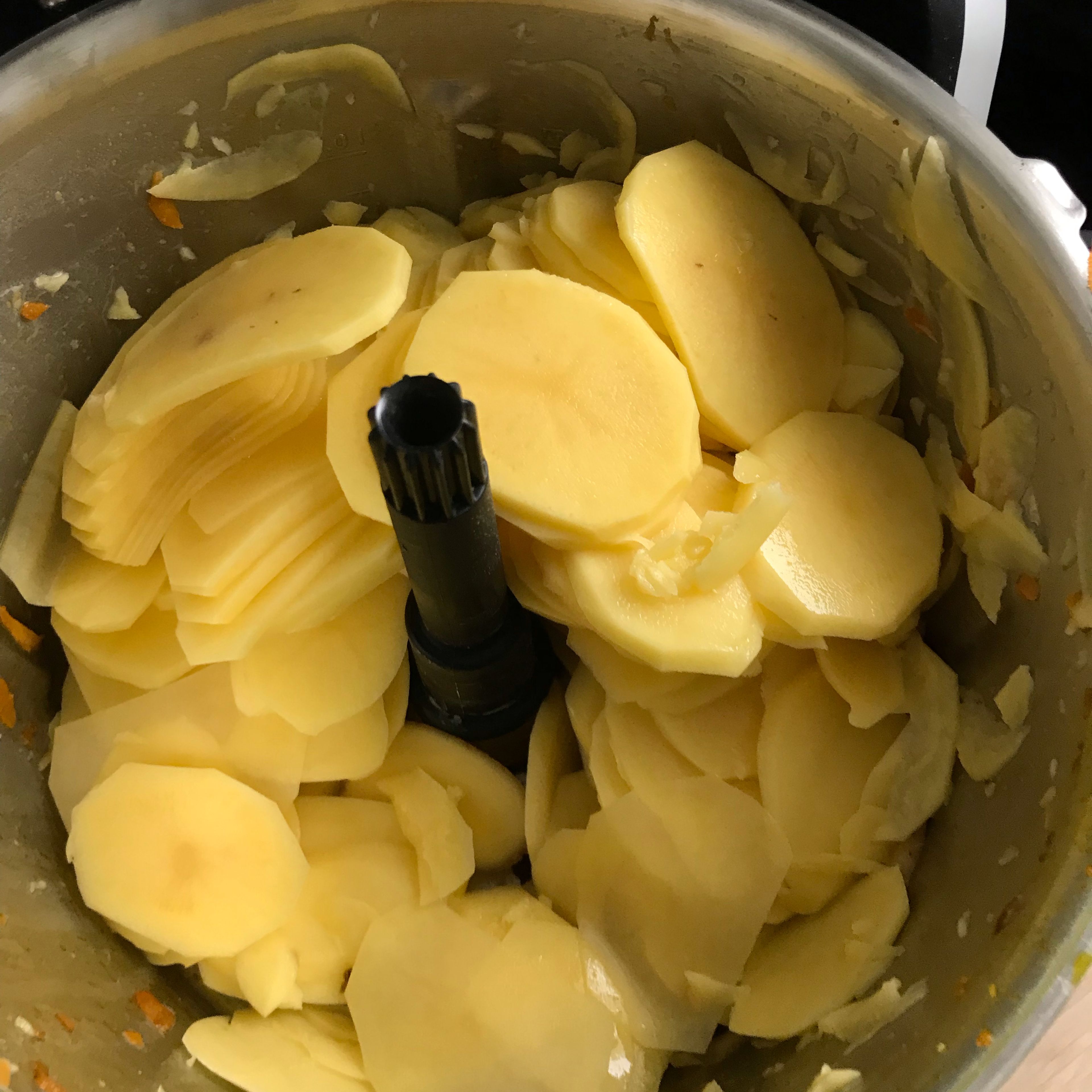 Die gewaschenen Kartoffeln schälen und mit dem groben Zerkleinerungsaufsatz hobeln. Anschließend in eine Auflaufform geben. (Zerkleinerungsaufsatz | Stufe 6)