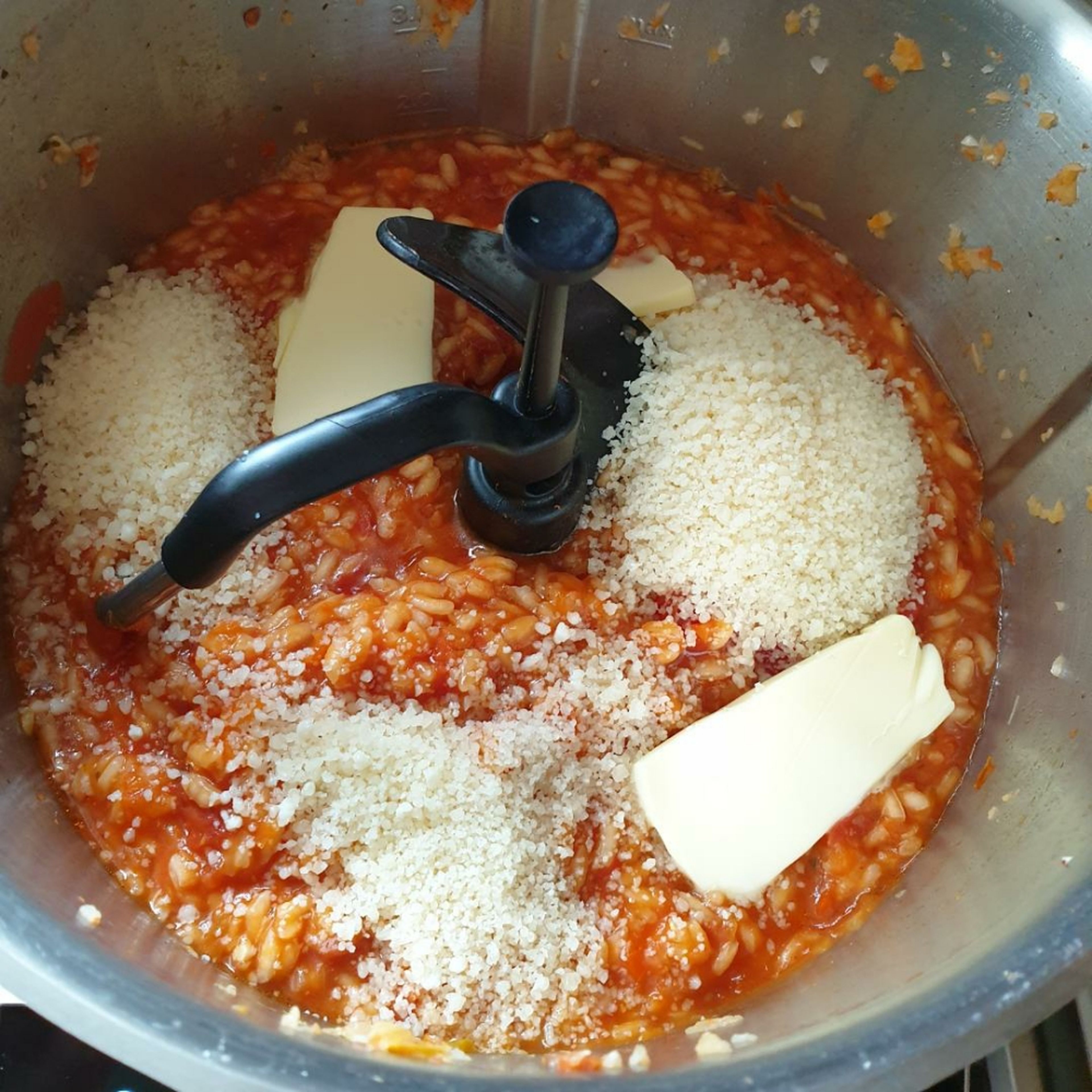 Die Butter und die Hälfte des geriebenen Parmesans auf das Risotto geben. Außerdem mit Salz, Pfeffer und Chili abschmecken. Alles noch einmal kurz bei geschlossenem Deckel und eingesetztem Messbecher verrühren (3D-Rührer | Stufe 5 | 30 Sekunden).