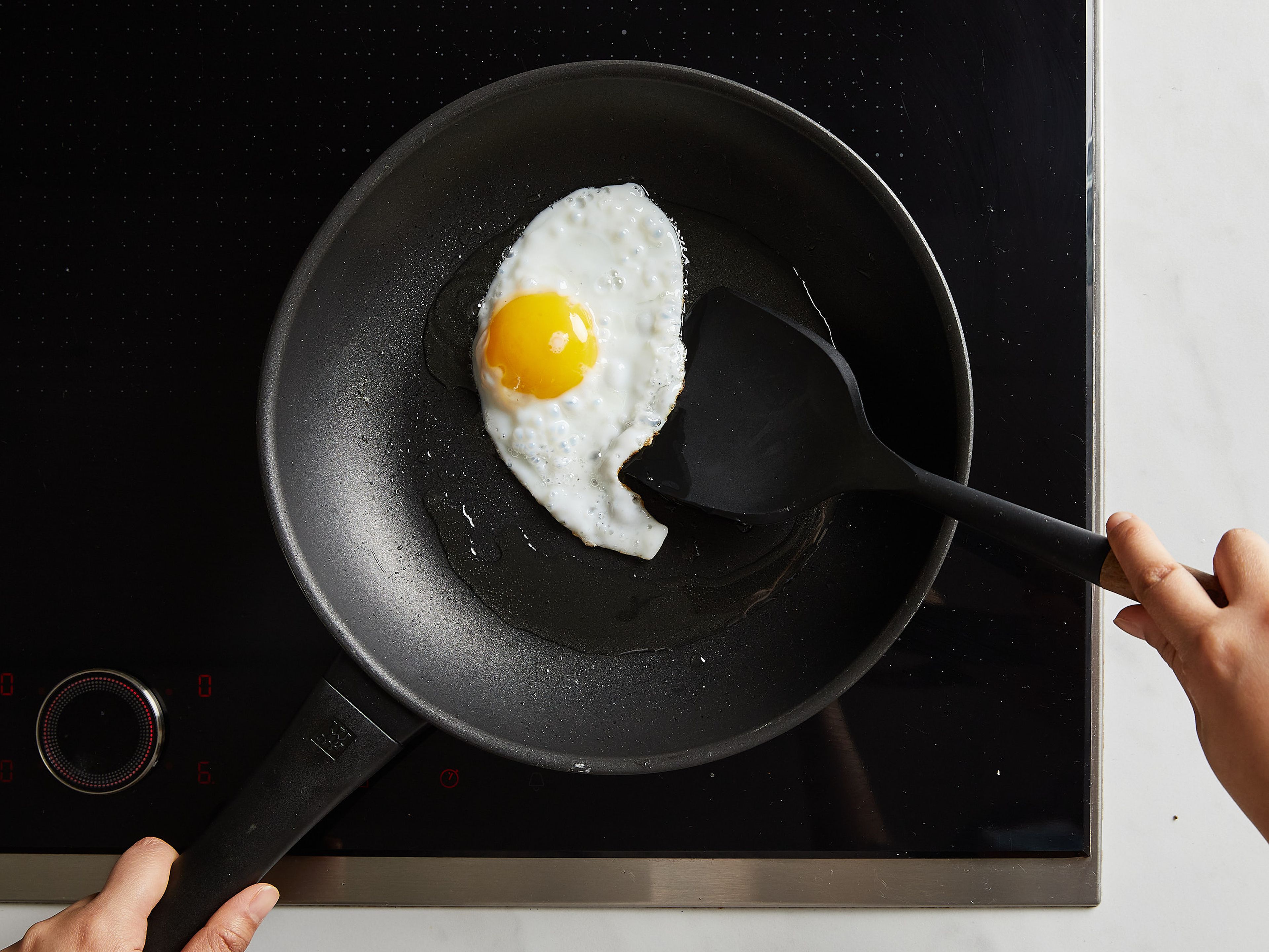 In einer Pfanne Öl bei mittlerer bis hoher Hitze erhitzen. Die Eier hineinschlagen und braten, bis der Rand knusprig ist und das Eiweiß gestockt ist. Herausnehmen und beiseite stellen.