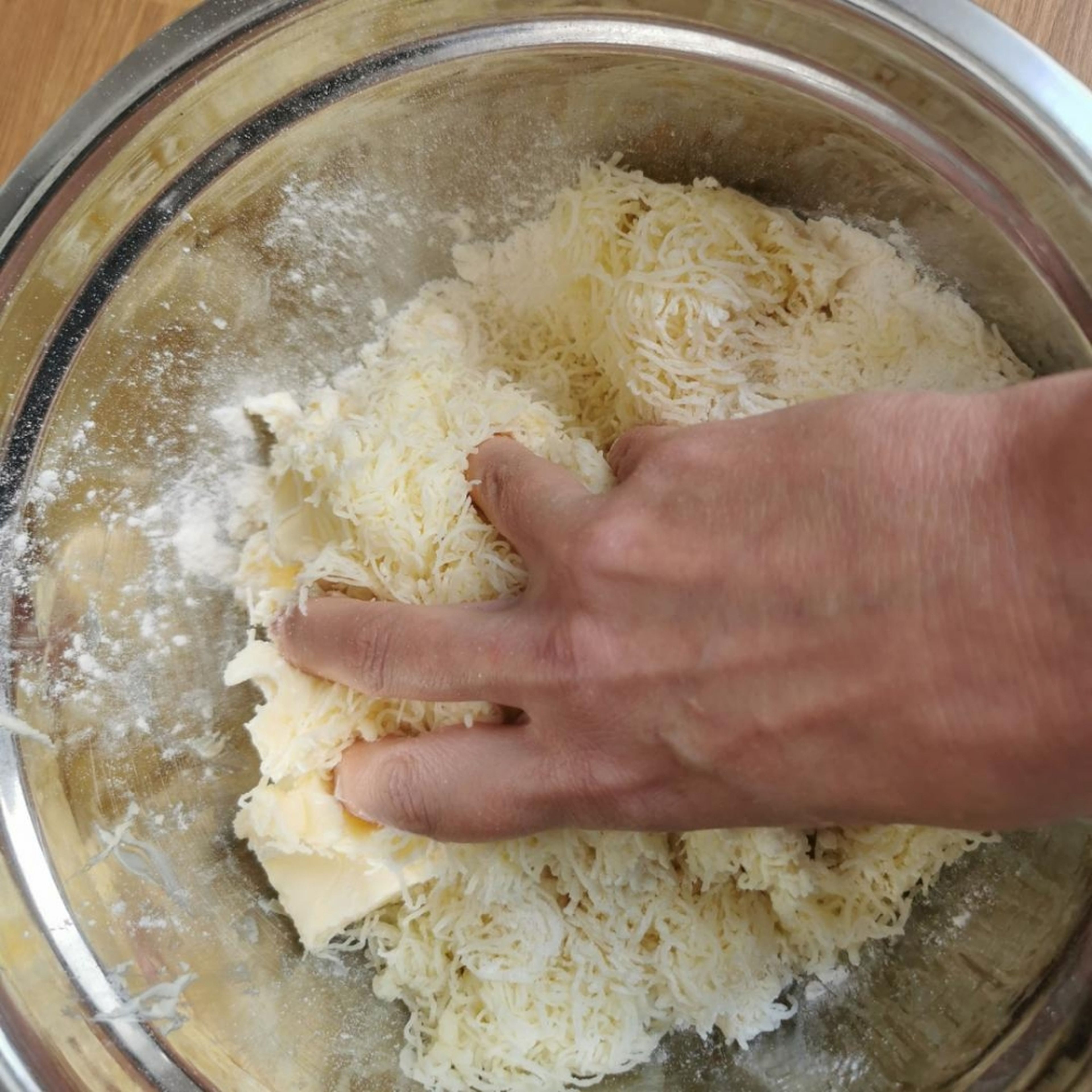 Mehl, Butter, Käse per Hand zu einem glatten Teig kneten. Salz und geriebenen Kümmel nach Geschmack sowie die Prise Zucker hinzufügen.