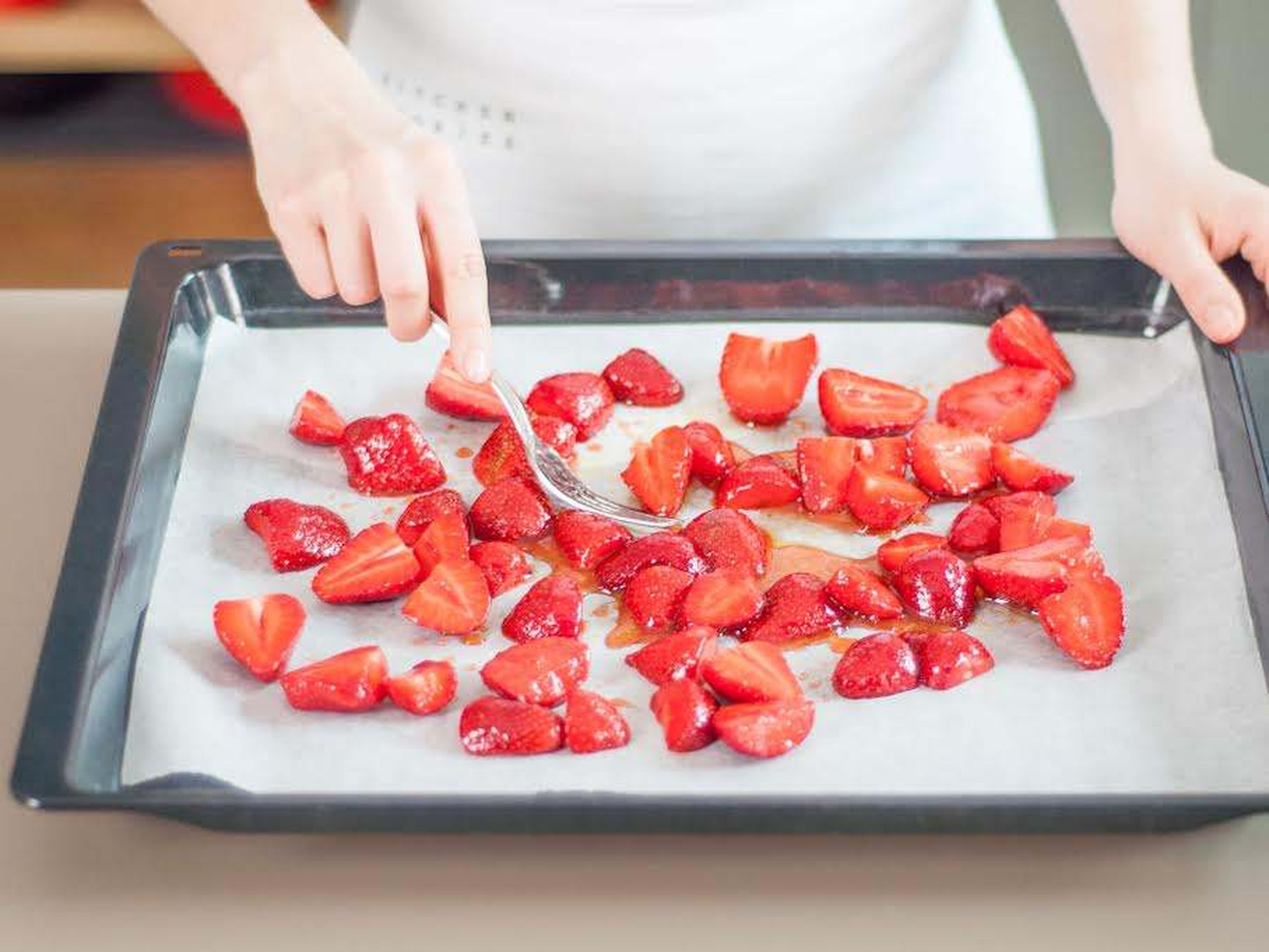 Erdbeeren nebeneinander auf Backblech verteilen und ca. 30 - 40 Min. bei 190°C backen, oder bis die Flüssigkeit eindickt. Danach Erdbeeren zurück in die Schüssel geben, einen Teil des Balsamicoessigs dazugeben und Erdbeeren darin schwenken, bis sie vollständig ummantelt sind. Beiseitestellen.