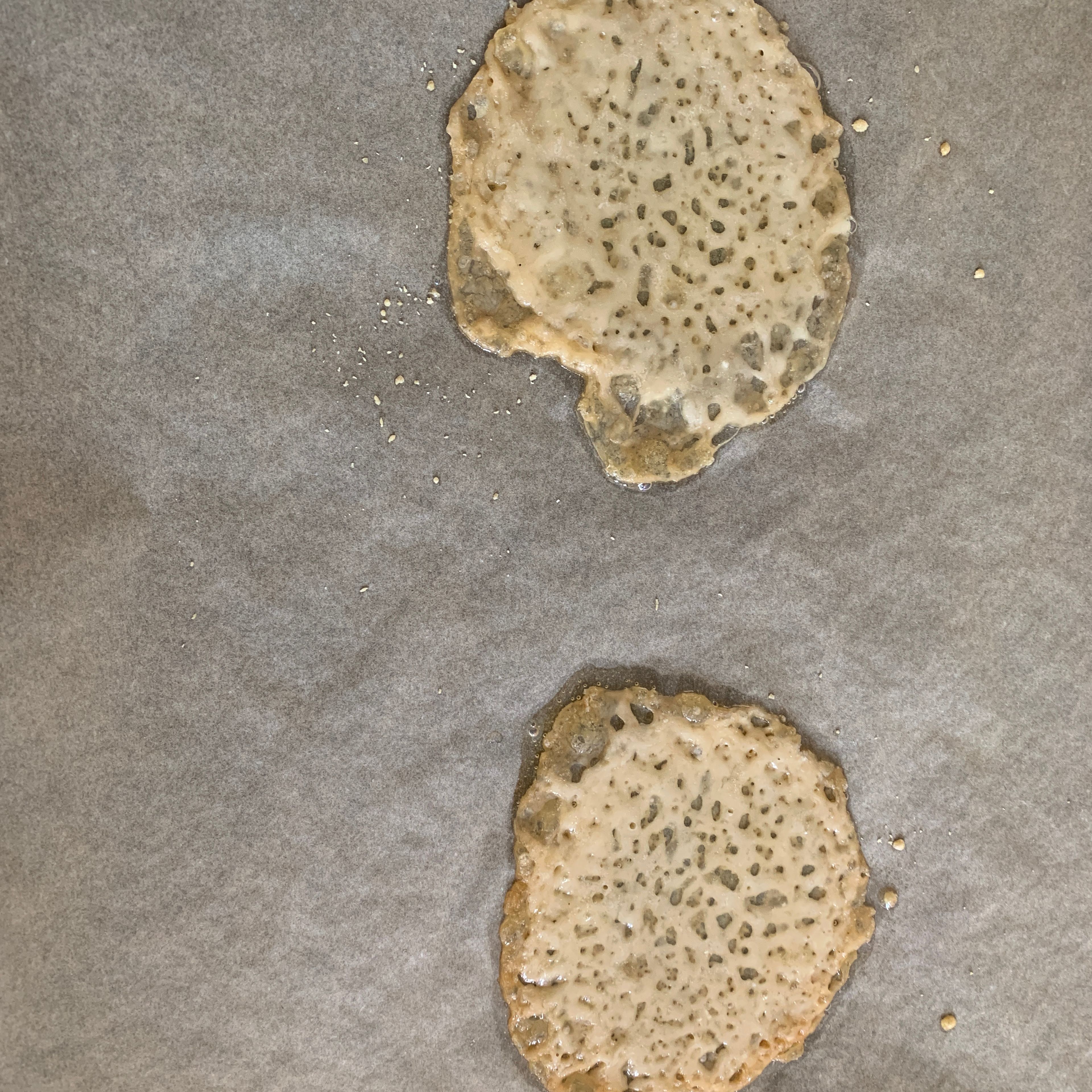 Parmigiano Reggiano reiben und 2 runde Häufchen auf einem mit Backpapier ausgelegten Backblech legen. Im vorgeheizten Backofen bei 180 Grad Umluft für 7 Min backen.
