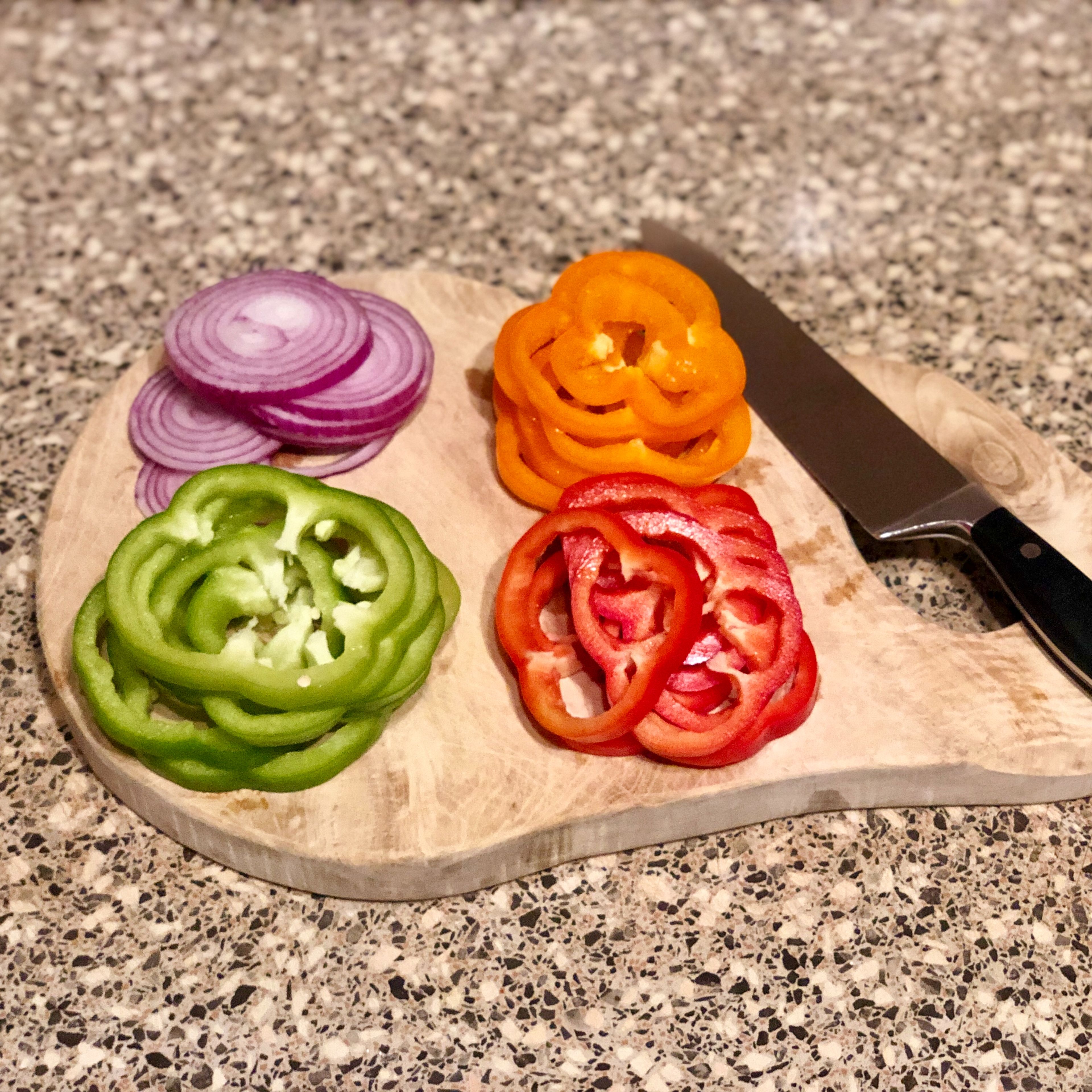 Cut tricolor bell peppers and red onion into rings.