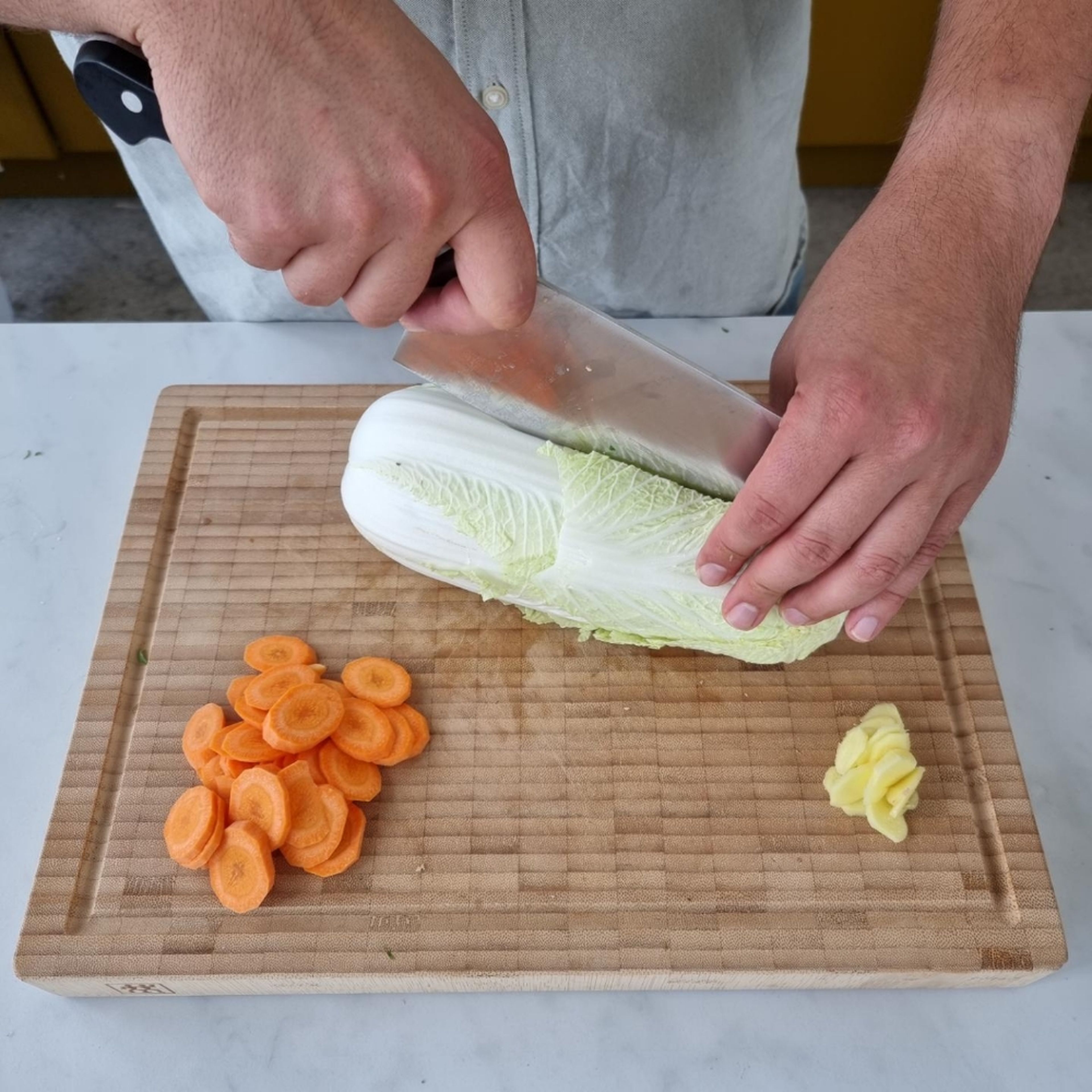 Cut carrot into thin slices. Roughly cut the cabbage into pieces. Cut the white of the scallion into 1 cm pieces. Peel ginger and cut into fine cubes.
