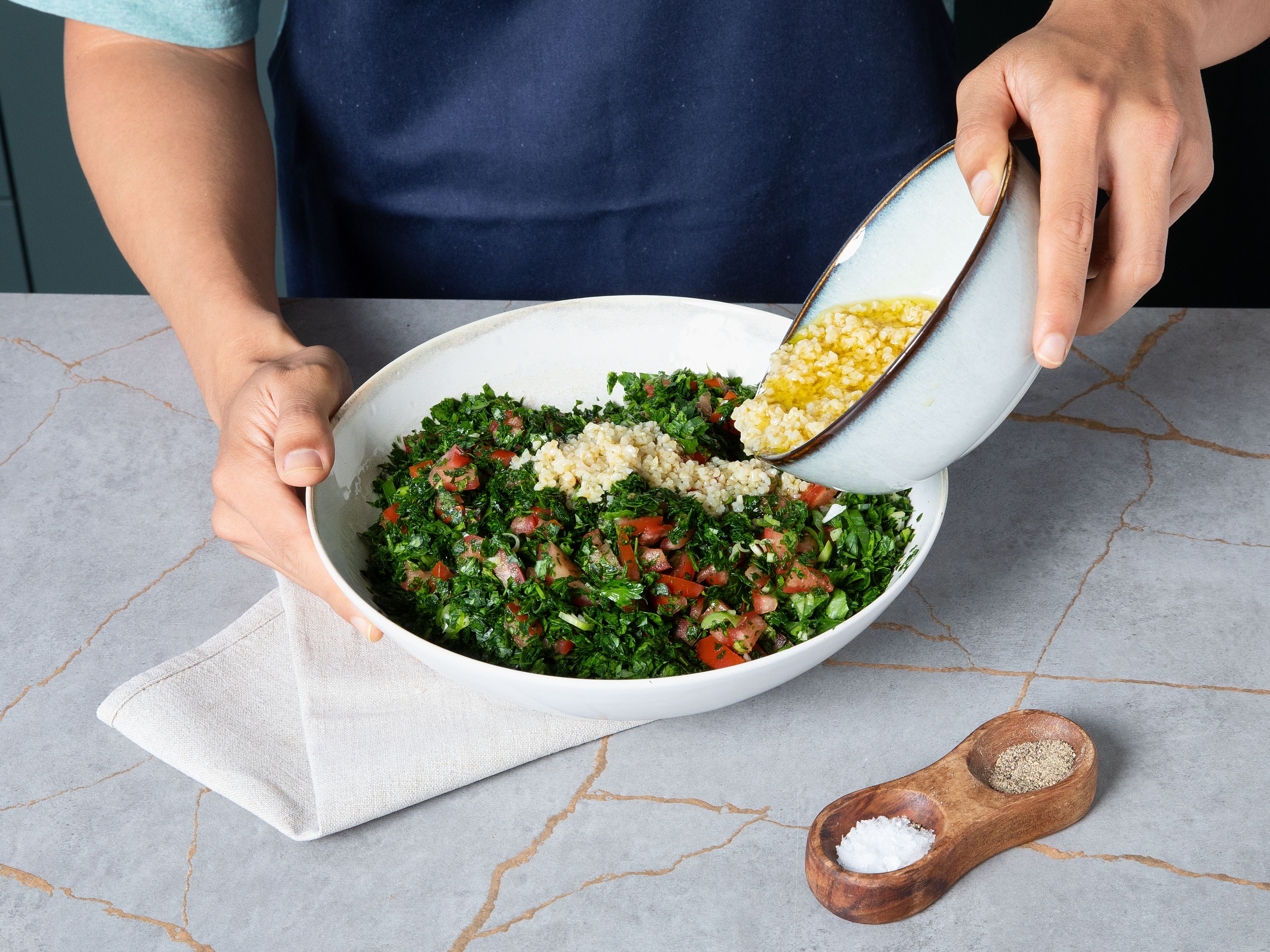 Den eingeweichten Bulgur zur Gemüsemischung geben und vermengen. Tabbouleh abschmecken und bei Bedarf mit zusätzlichem Salz, Pfeffer oder Zitronensaft nachwürzen und sofort servieren.