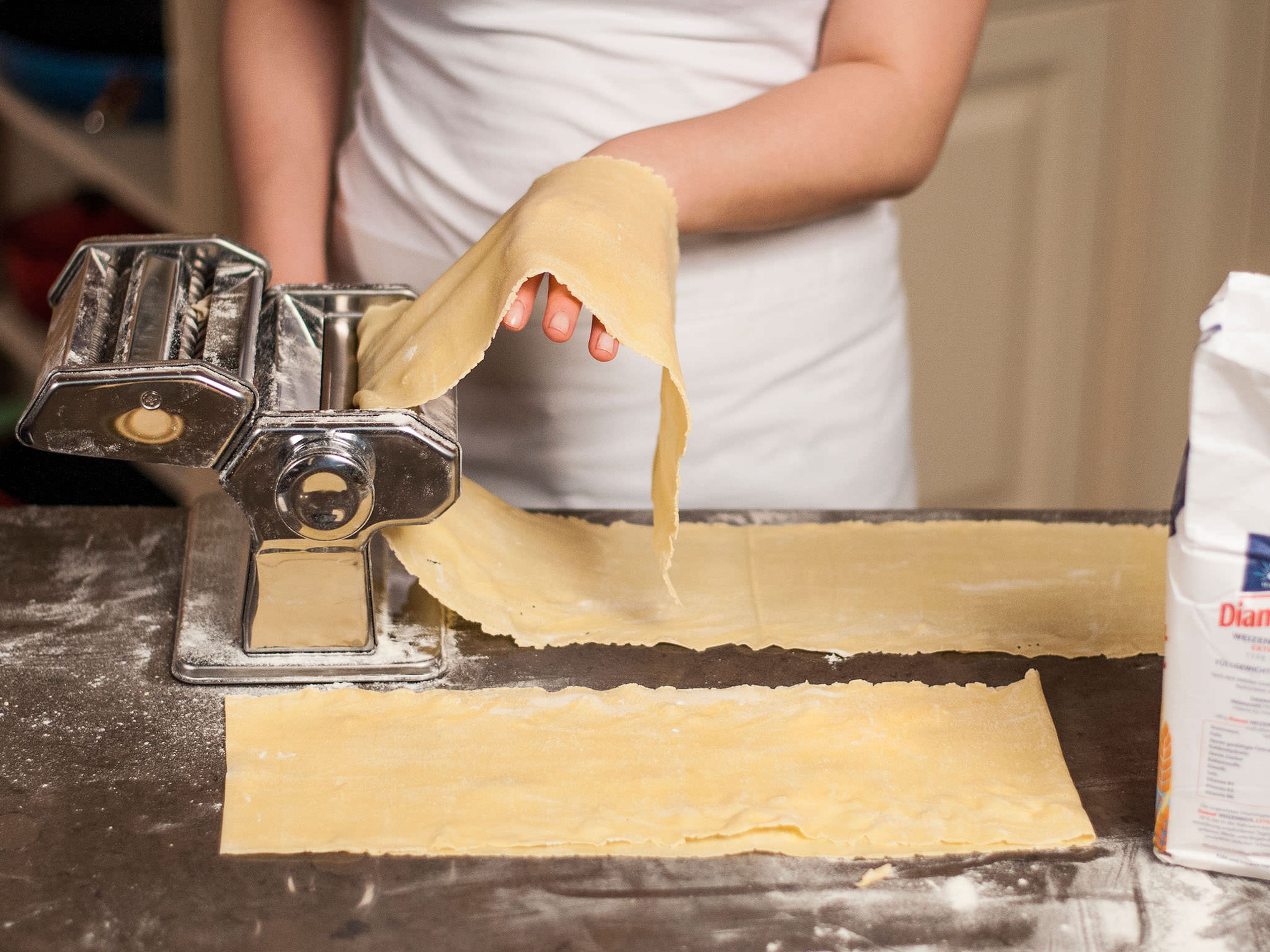 Halve pasta dough. Roll out both halves as thinly as possible on a floured surface with a rolling pin or a pasta machine into 5 cm x 40 cm strips.