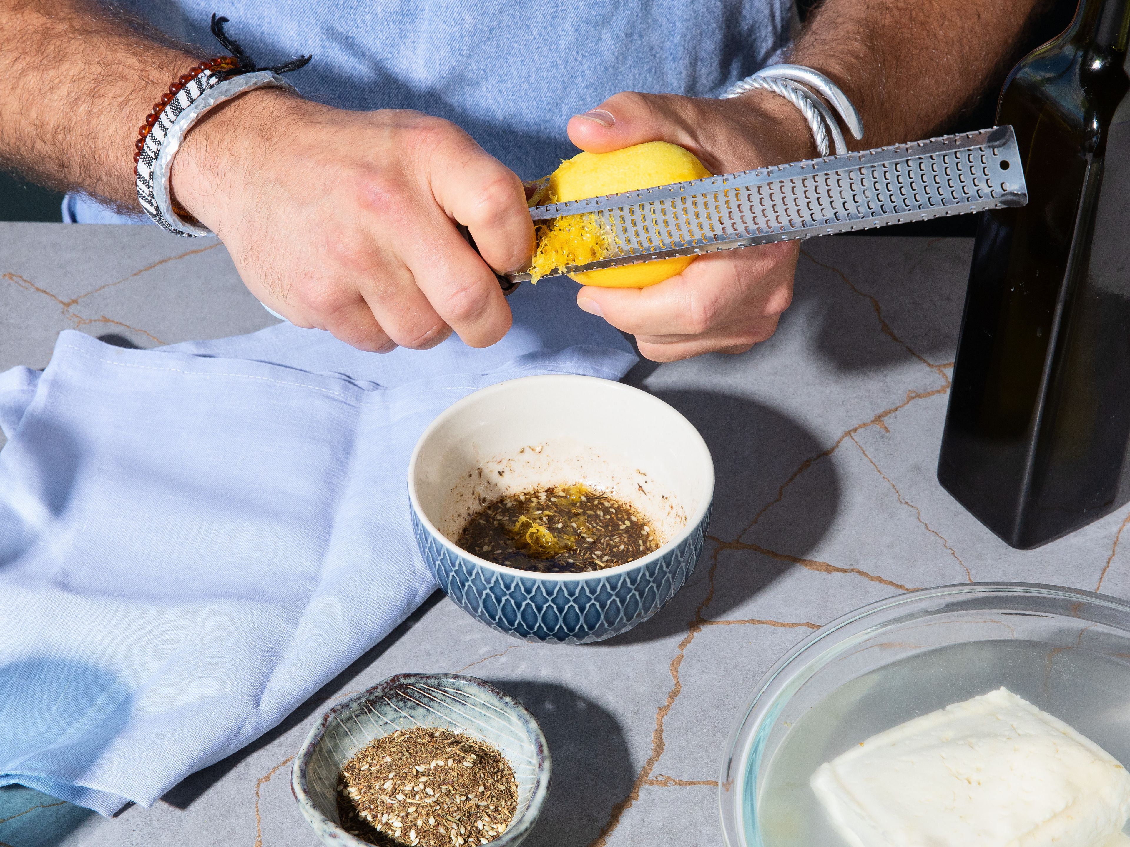 Heat up oven on fan 200°C/392°F. Soak halloumi in warm water until ready to fry approx. 10–15 min., then pat dry. Meanwhile zest lemon into a bowl, add zaatar, olive oil, honey, red wine vinegar and mix. Season with salt and pepper.