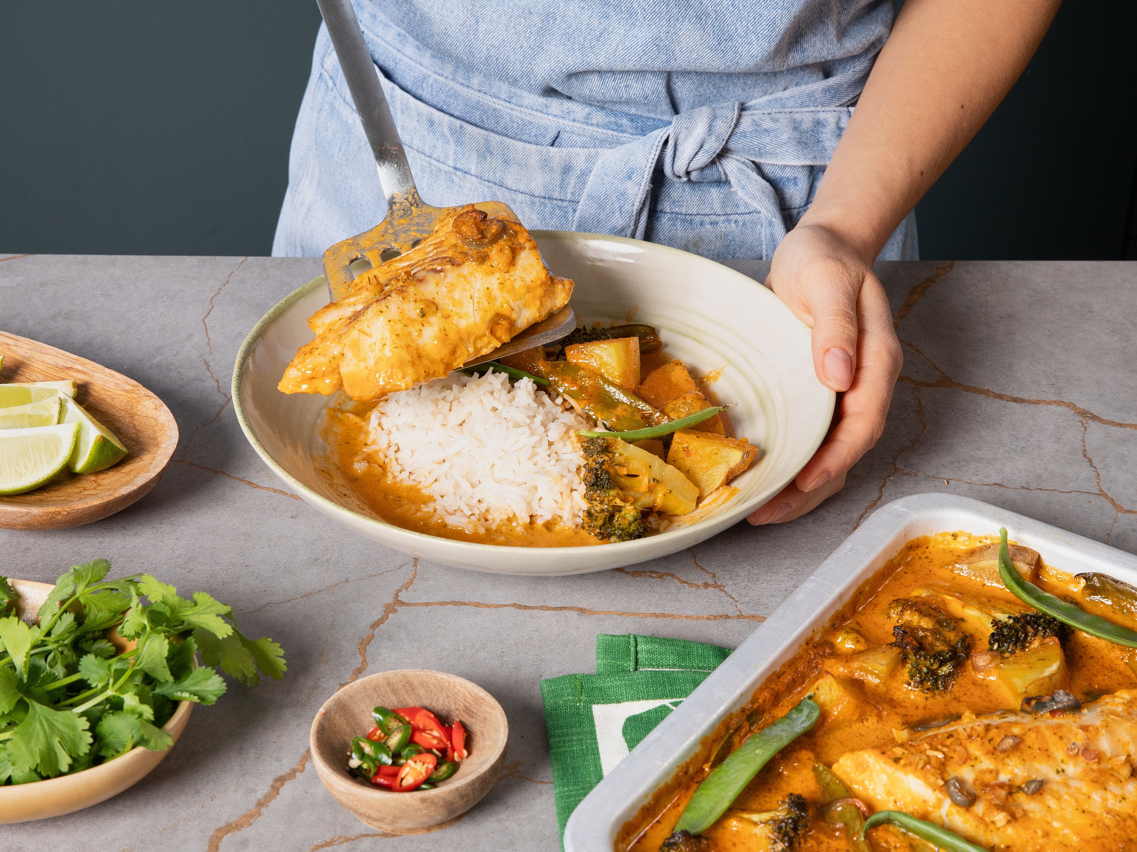 Im vorgeheizten Ofen ca. 20 Min. backen, bis der Fisch und das Gemüse gar sind. Nach Belieben mit gekochtem Reis, frischem Koriander und Limettenspalten servieren.