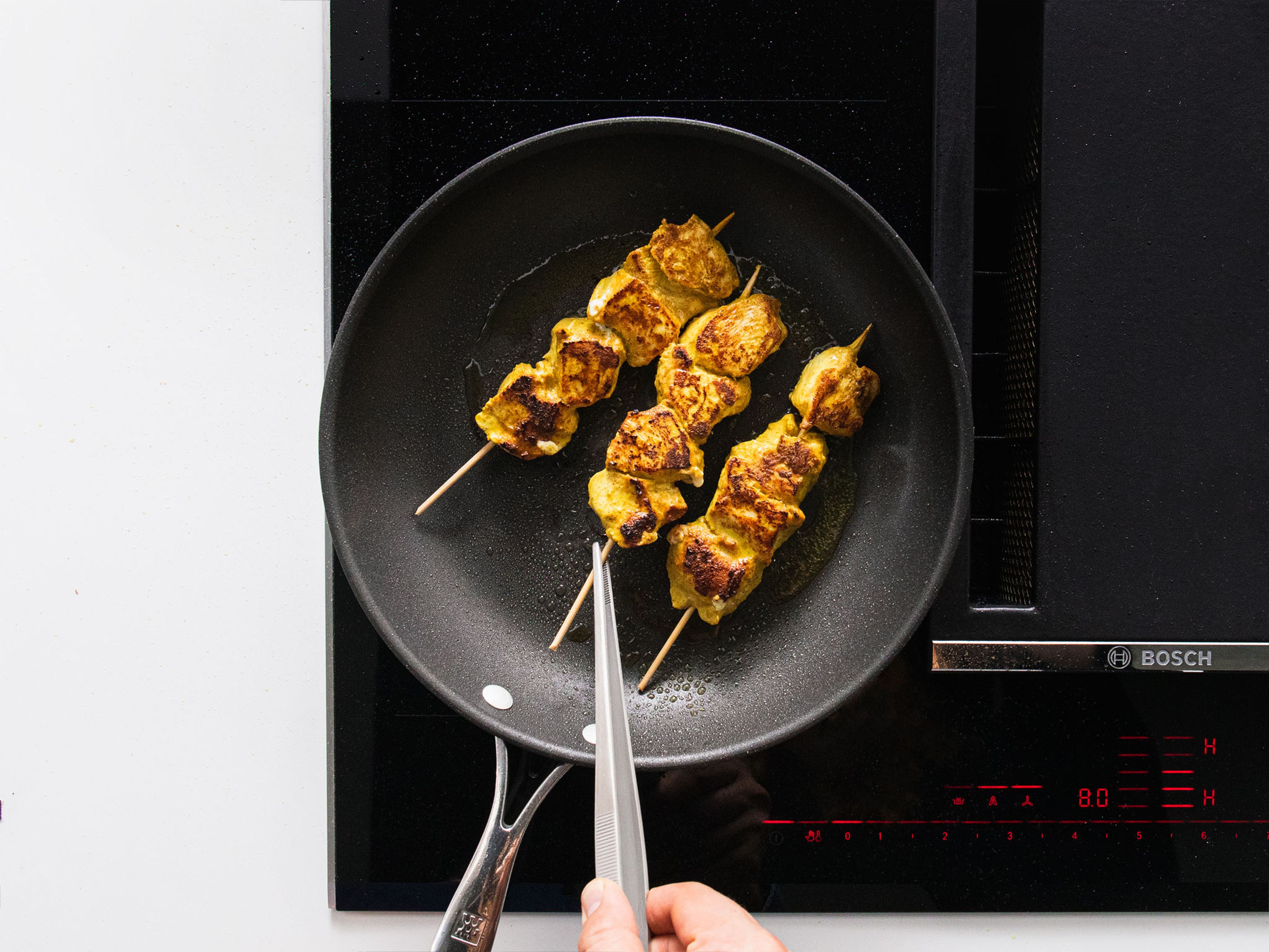 Heat some vegetable oil in the same pan and fry chicken skewers on all sides until well-browned and cooked through. Serve with pita bread, salad and dressing, fresh cilantro and mint, and yogurt dip. Enjoy!