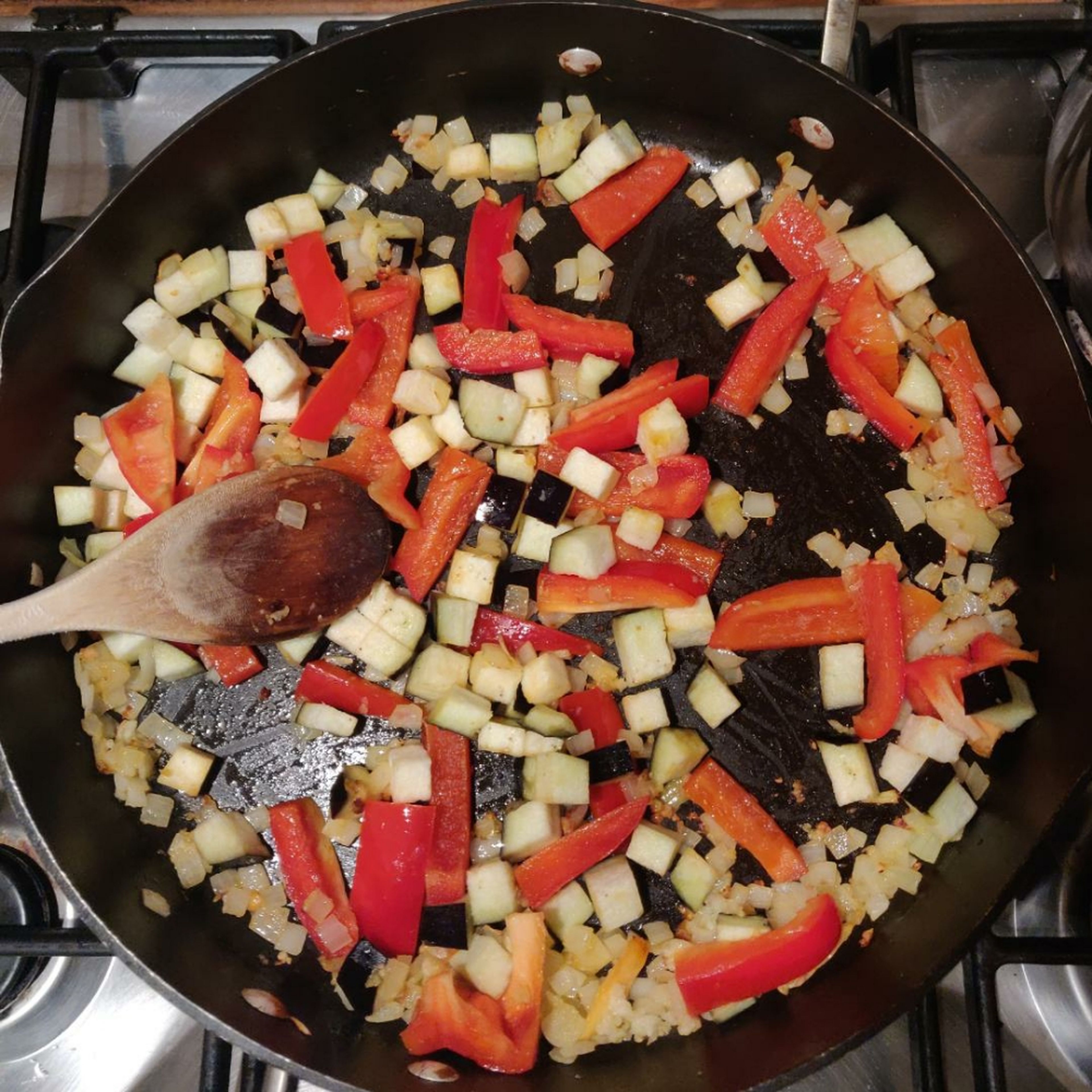 Finely chop onion, mince garlic and grate ginger. Heat olive oil in pan. Saute onion, garlic and ginger until fragrant. Add in chopped red bell pepper and cubed eggplant and saute for 3 to 5 mins.