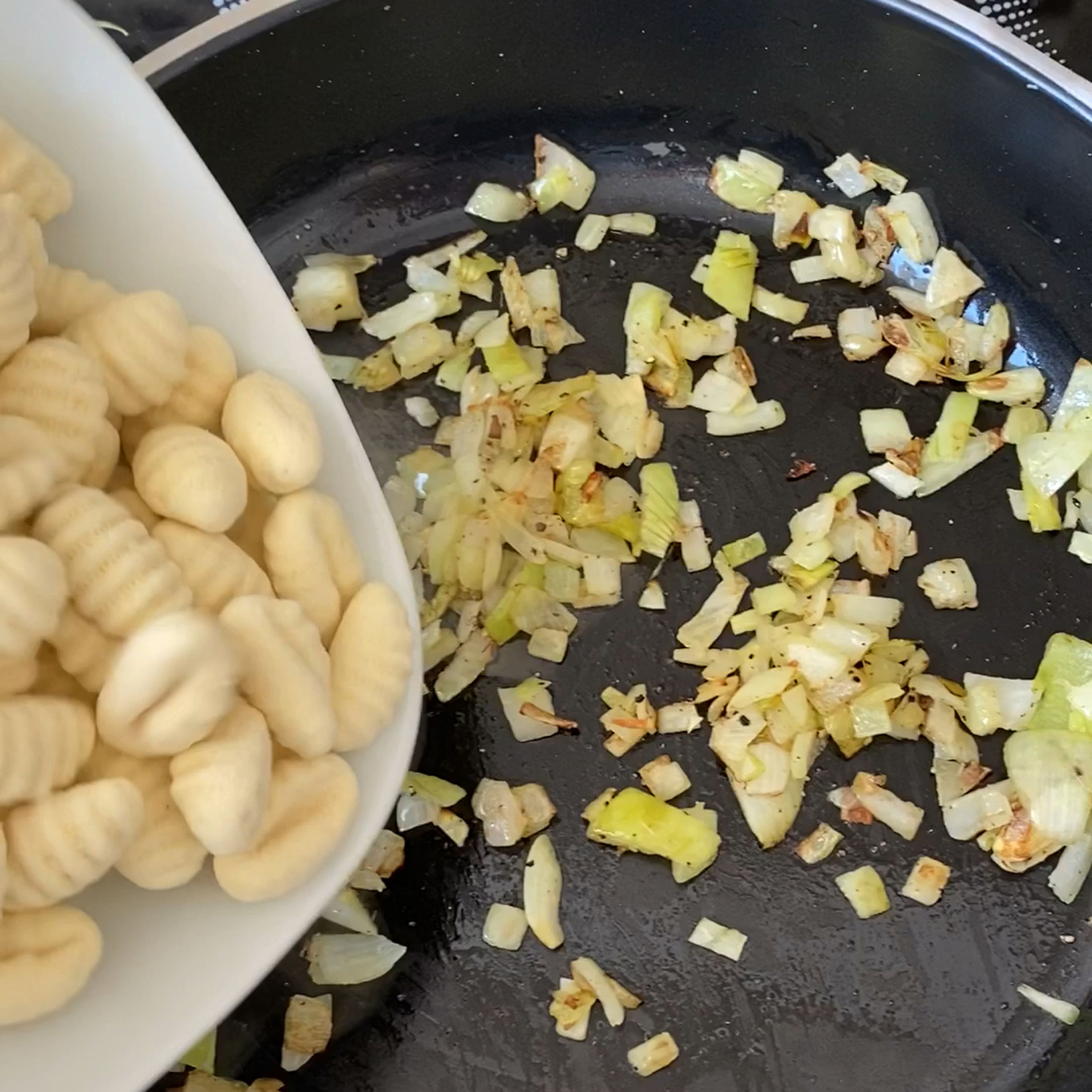 Wenn die Zwiebel glasig sind, die Gnocchis dazu geben und mit anbraten. Danach mit etwas Gemüsebrühpulver und Wasser ablöschen.