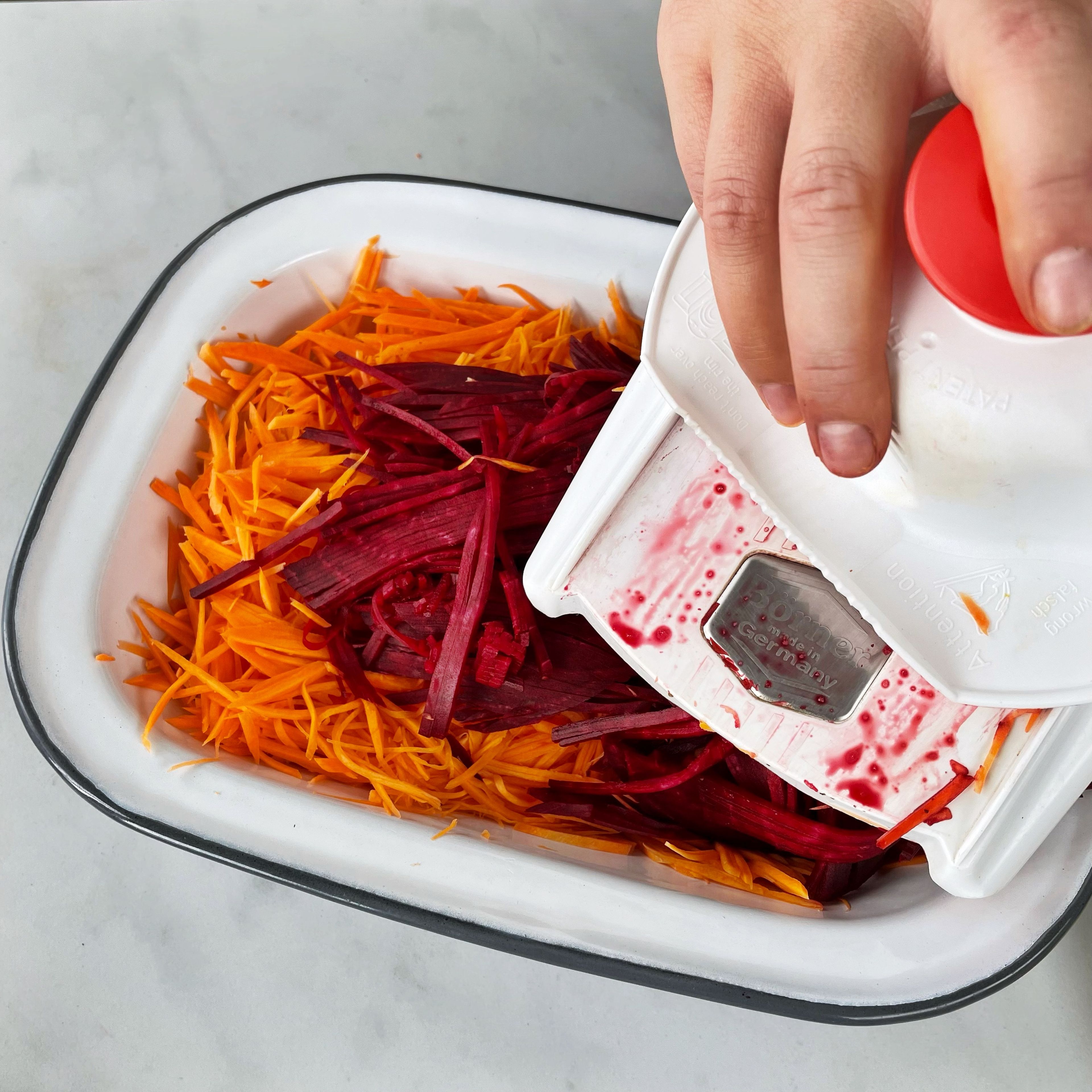 Peel the carrots and red beets and slice into fine julienne. Mix with vinegar, olive oil, chili flakes, salt and pepper and knead briefly with your hands. Then arrange on plates and garnish with the pistachios, cranberries and mint.