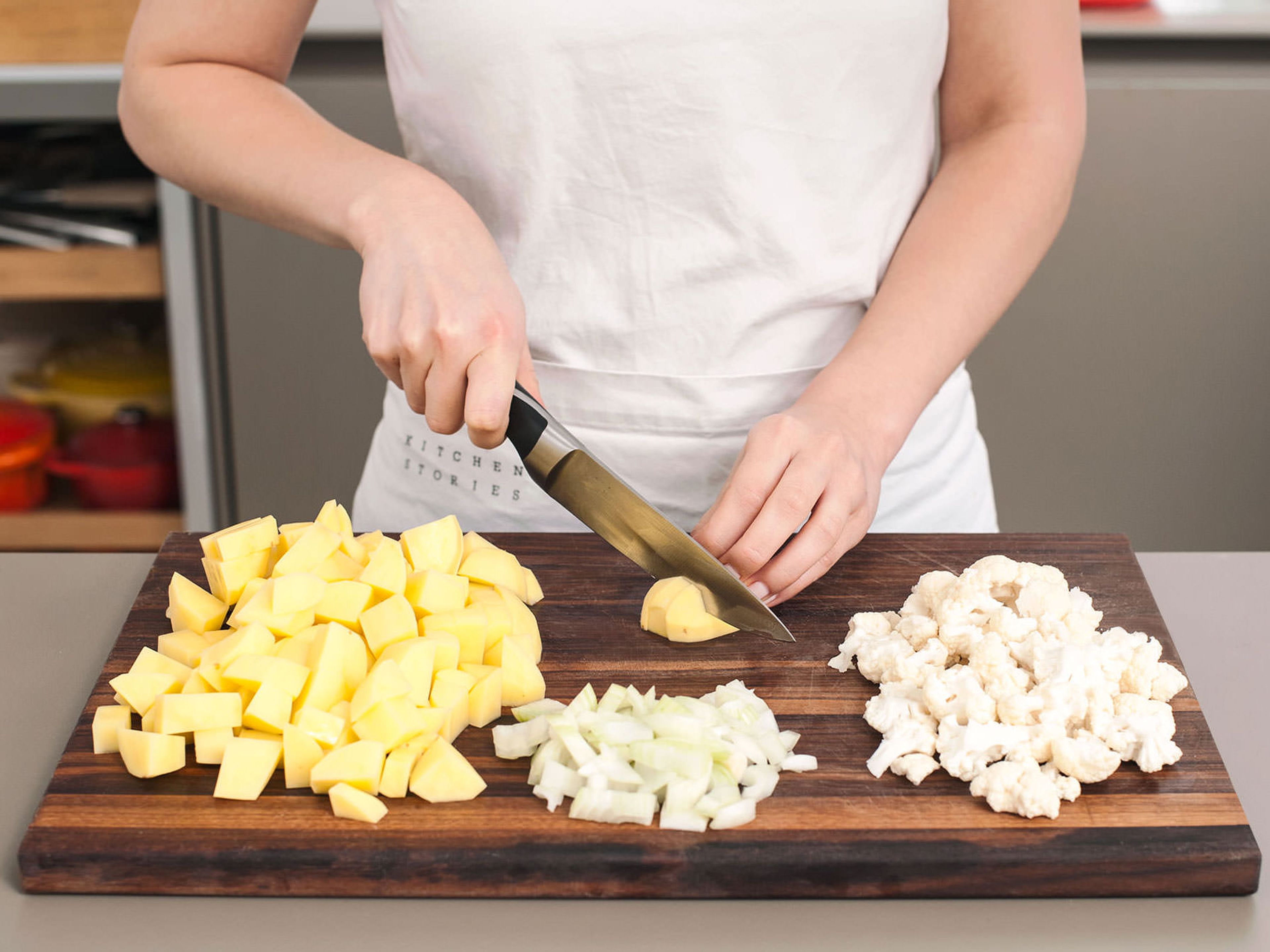 Kartoffeln schälen und in ca. 2 cm große Würfel schneiden. Zwiebel hacken und Blumenkohlröschen vom Strunk schneiden. Baconscheiben halbieren.