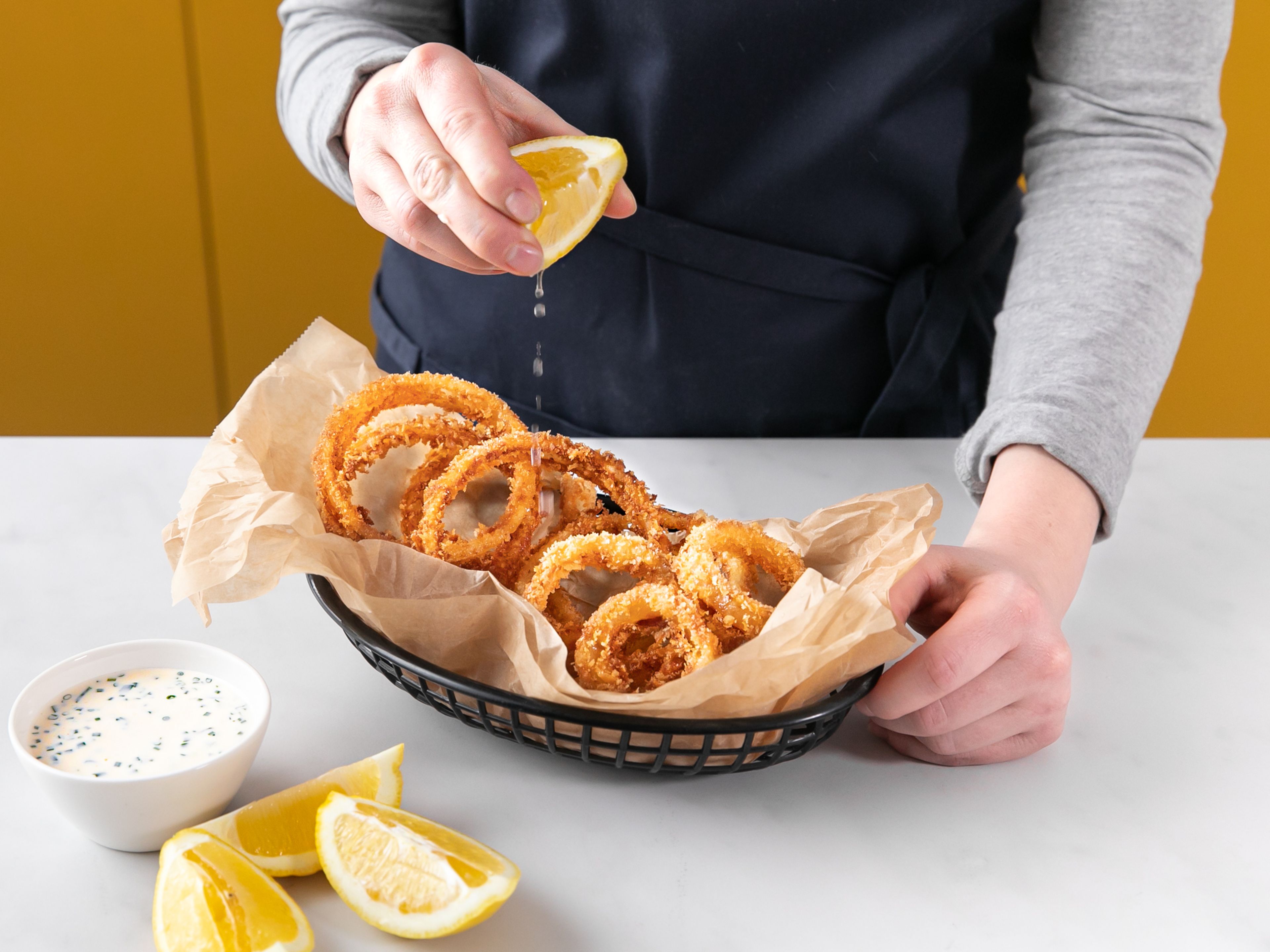 Serve hot onion rings with the spicy ranch dip and lemon wedges. Enjoy!