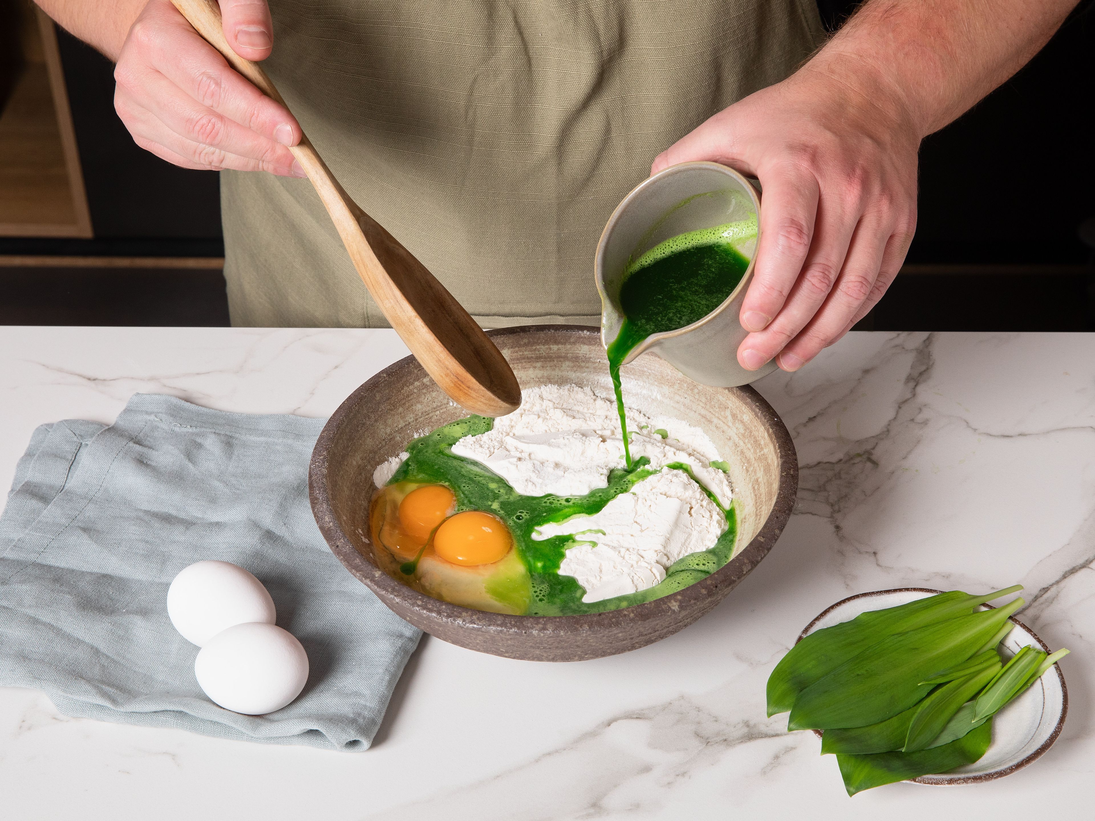 Combine wild garlic and water, then blend in a mixer until smooth. Add flour, a pinch of salt, wild garlic puree, and eggs into a bowl and mix into a smooth Spätzle dough. Beat dough vigorously until small air bubbles begin to form, then let it rest for approx. 15 min. In the meantime, peel onions and slice them into thin half-rings.