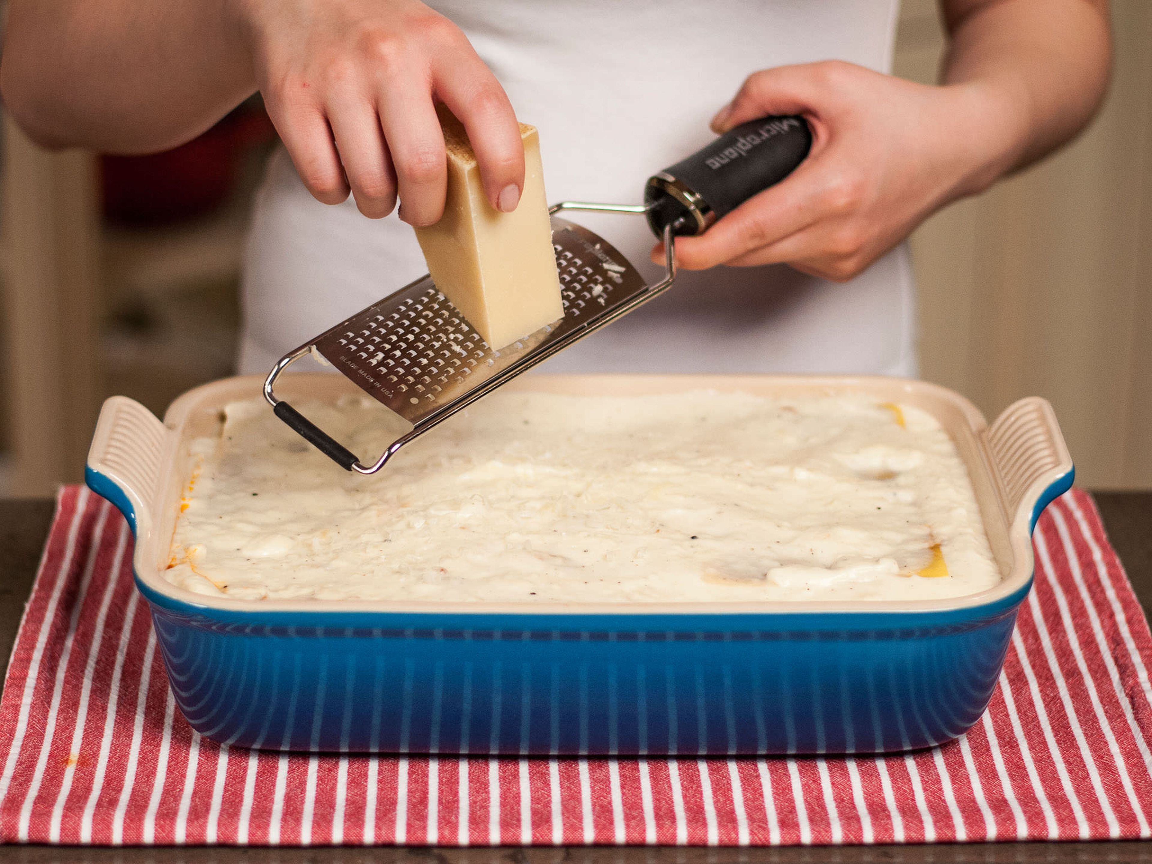 Den Parmesan über die letzte Schicht reiben und die Lasagne in einem vorgeheizten Ofen bei 200°C/390°F auf der mittleren Schiene für etwa 30-40 Min. backen, oder bis die Oberseite golden ist. In der heißen Auflaufform servieren. Guten Appetit!