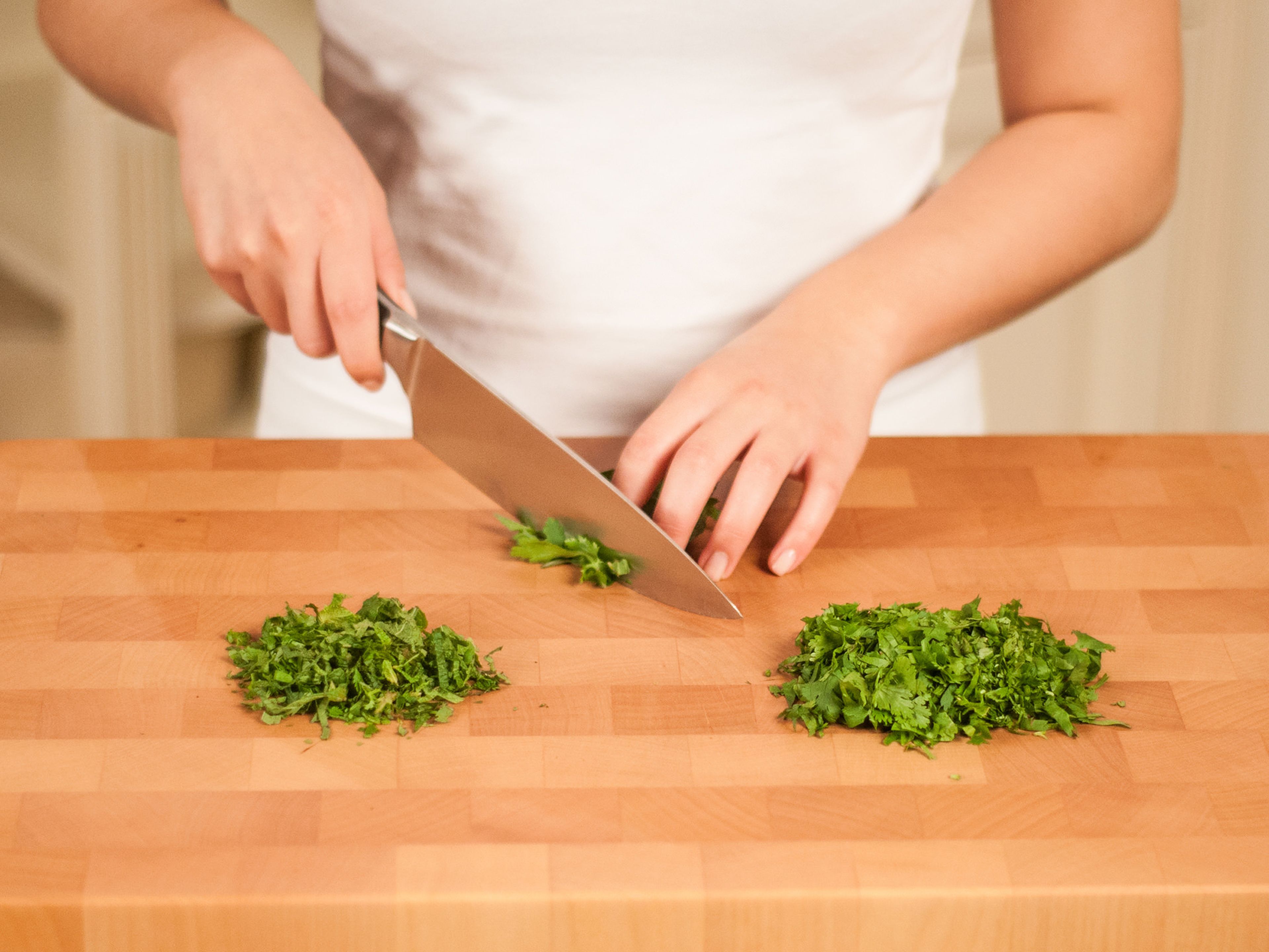 In the meantime, pick coriander, mint, and parsley leaves. Finely slice them.
