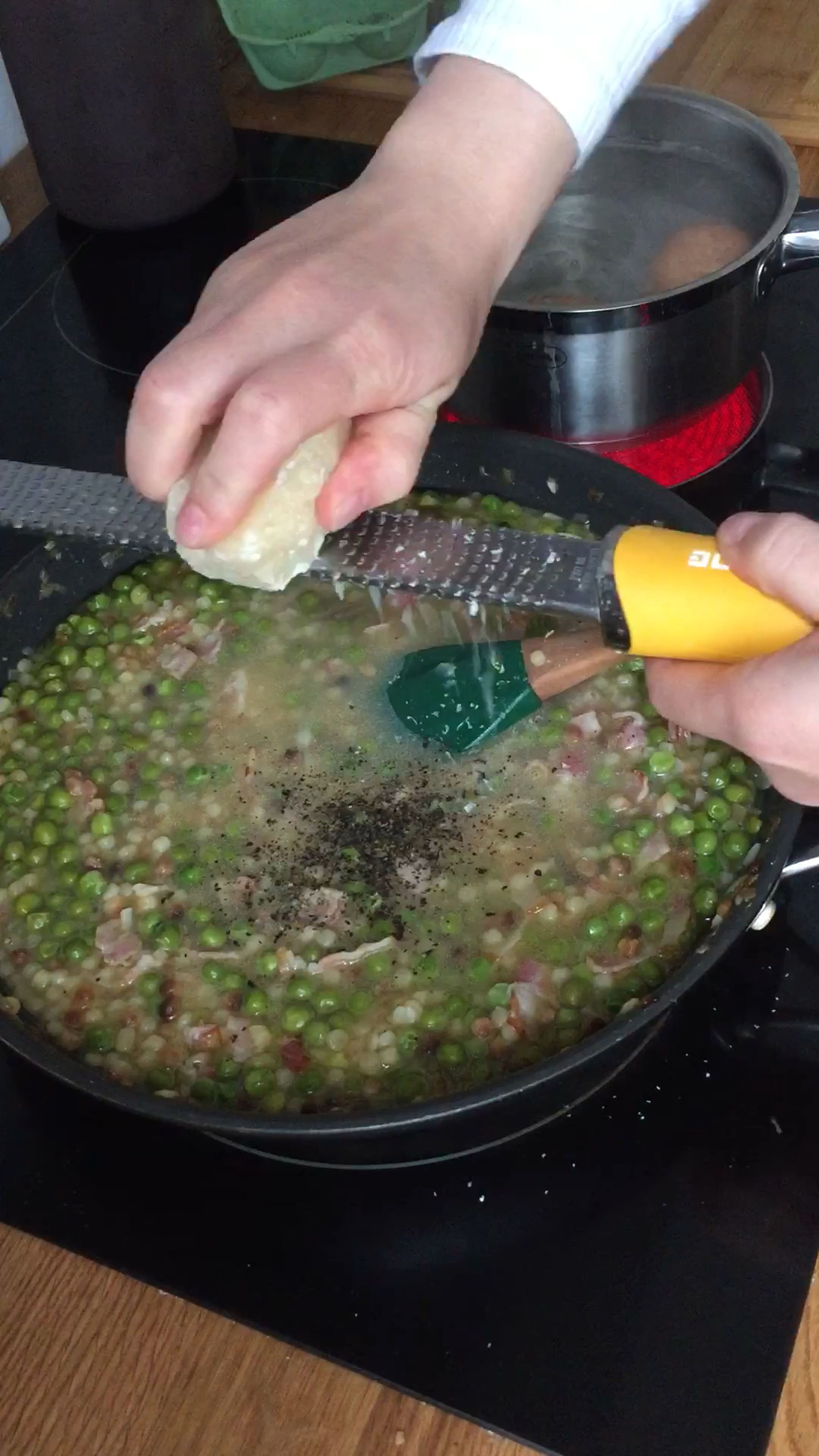 Die Eier für 6 min kochen. Pasta abgießen. Etwas Pastawasser auffangen und alles zu den Erbsen geben. Mit Salz und Pfeffer würzen, Parmesankäse dazugeben und verrühren. Zum Schluss den Abrieb und Saft einer Zitrone unterrühren.