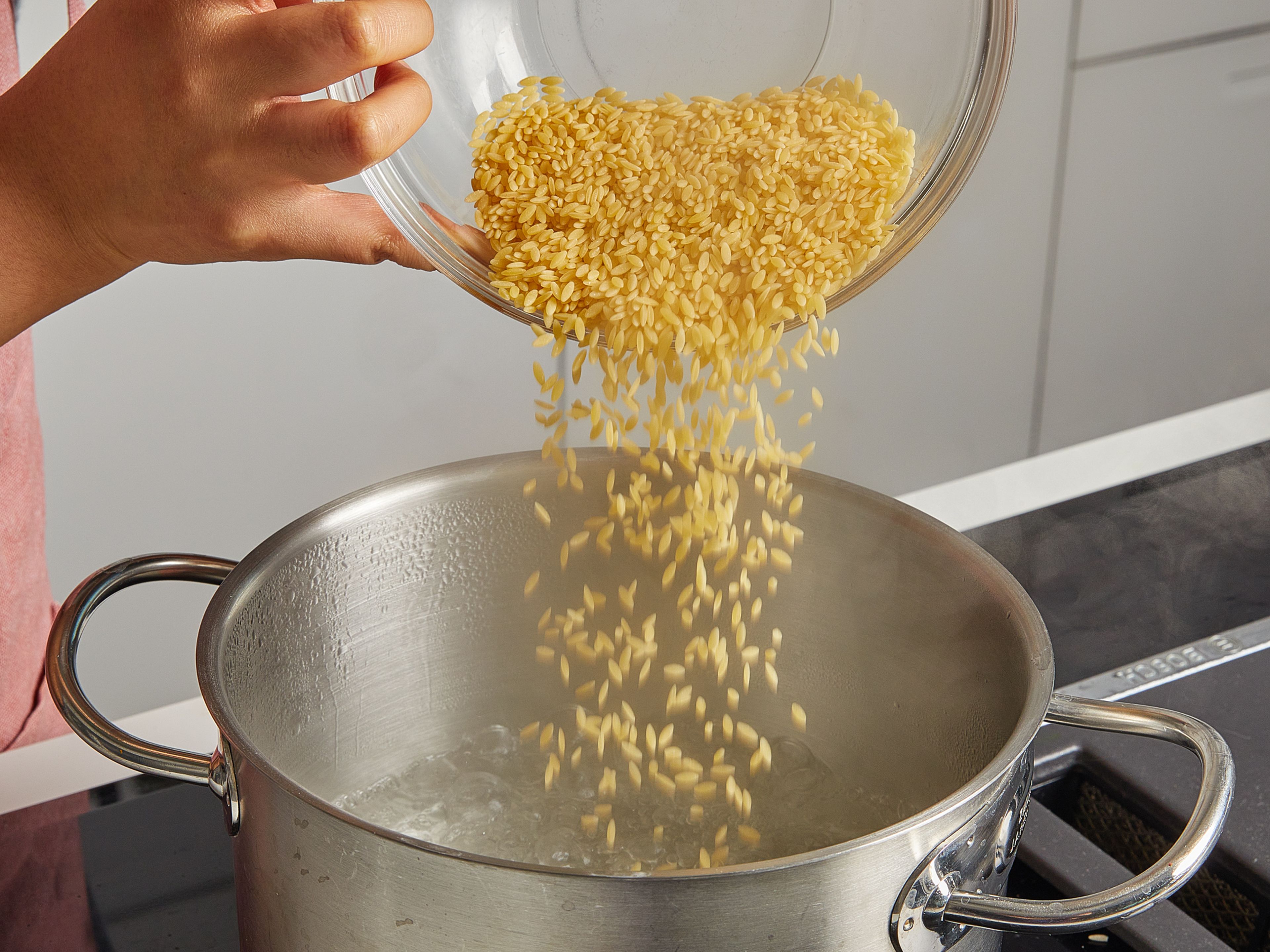 Meanwhile, in a large pot without oil, toast the almonds over medium heat until golden brown. Then take them out, roughly chop, and put them aside. Then, in the same pot, bring water to a boil and cook orzo pasta according to package directions until al dente.