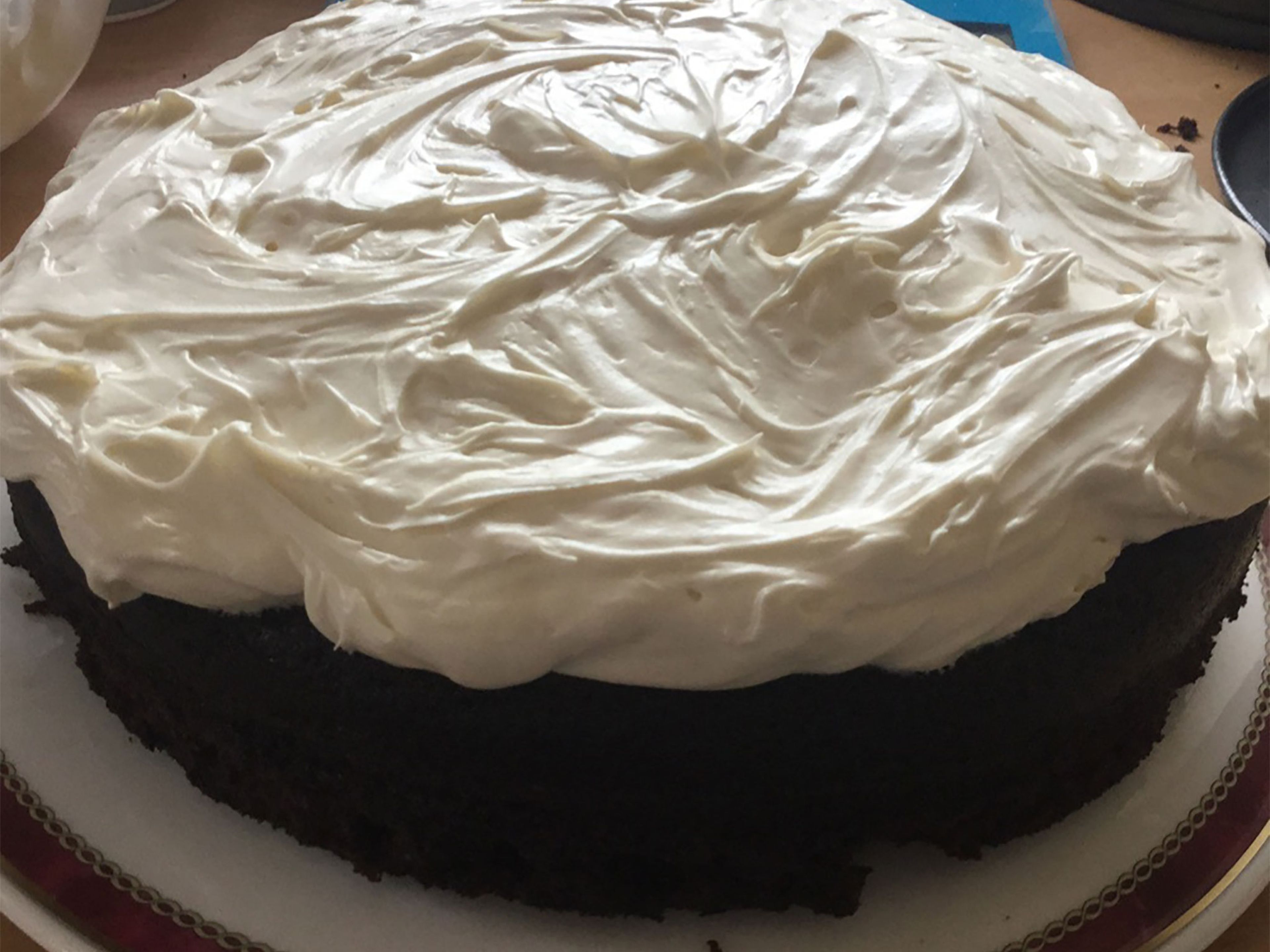 To make the frosting, lightly whip the cream cheese until it is smooth. Sift the powdered sugar into the cream cheese and beat them together. Add heavy cream and further beat to achieve a spreadable consistency. Spread the frosting on the cooled cake and serve.