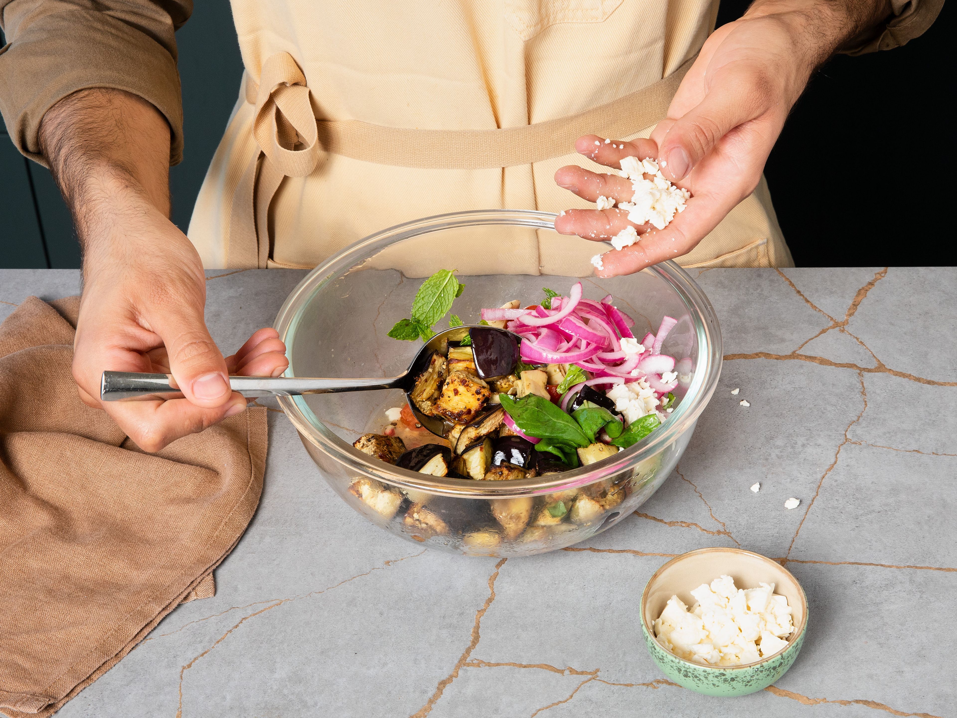 To the same bowl, add pickled red onion, crumbled feta, and pomegranate seeds. Once the eggplants are done, toss them in as well and mix the salad well. Garnish with more pomegranate seeds, herbs and feta to taste and serve.