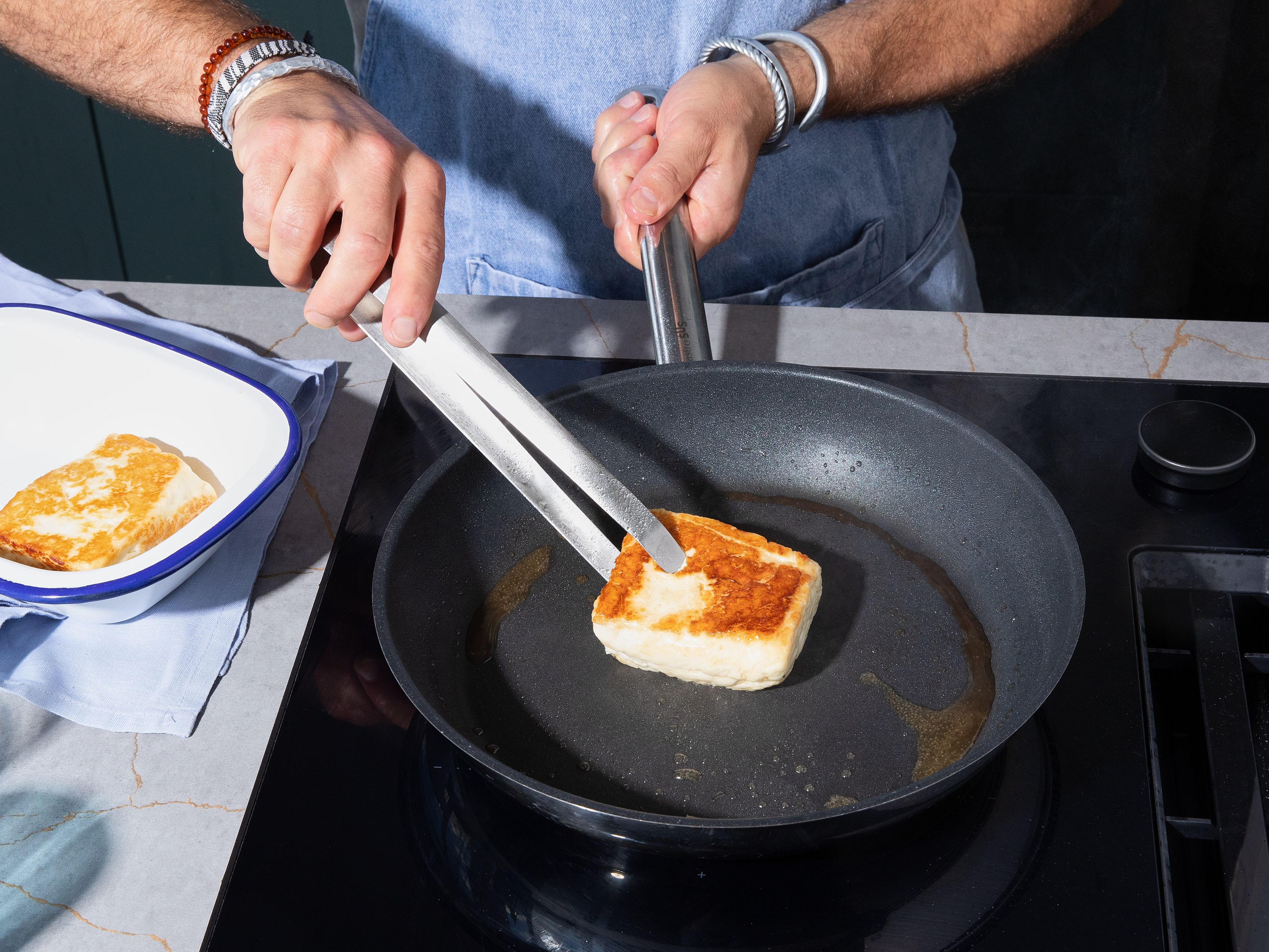 Heat up a small pan on medium-high heat. Add olive oil and fry halloumi blocks for approx. 2 min. on each side until slightly charred. Remove from pan into a small baking dish.