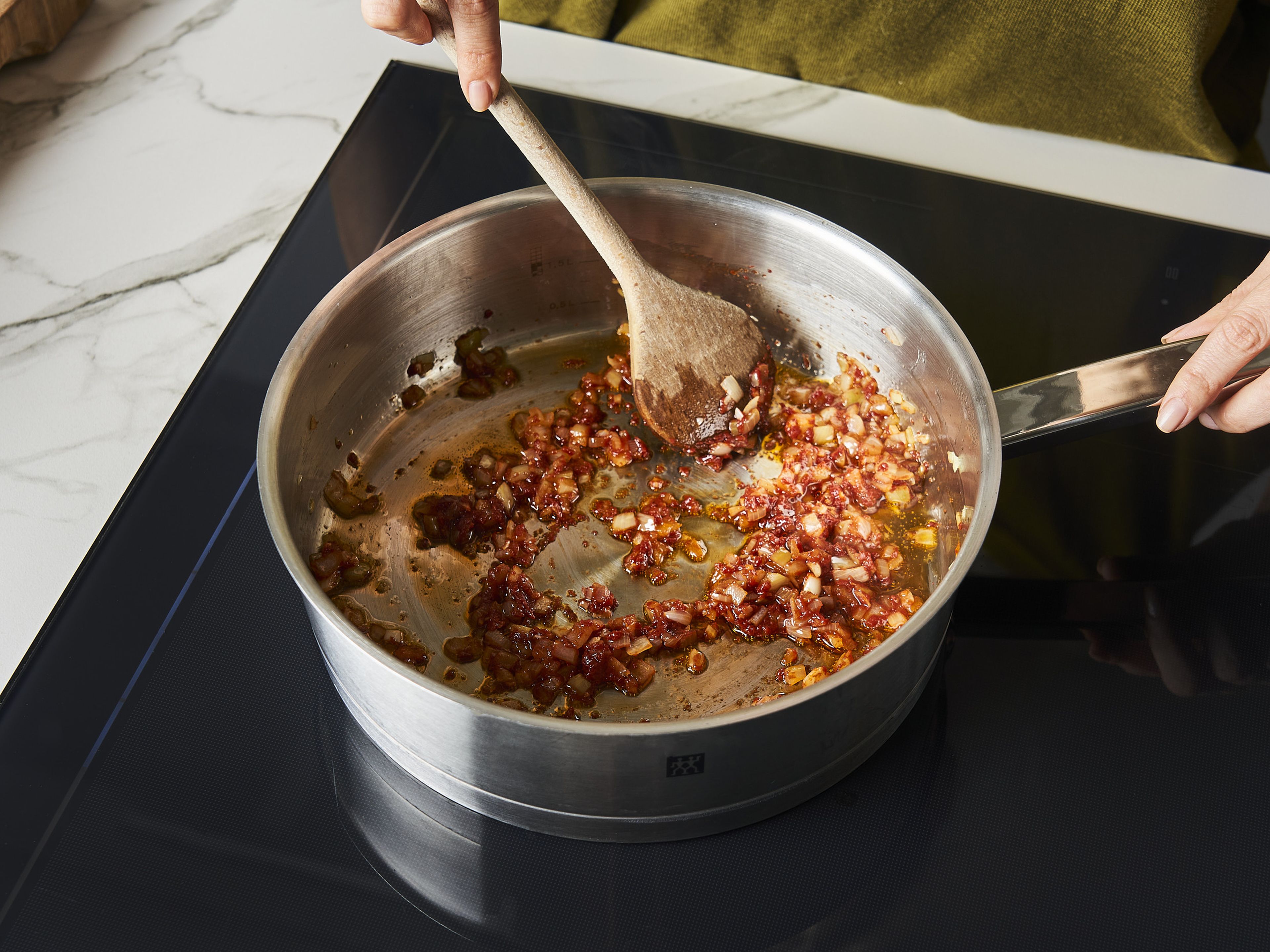 Etwas Olivenöl in einem großen Topf erhitzen. Zwiebeln und Knoblauch hinzugeben bei mittlerer Hitze für ca. 5–7 Min. glasig anbraten. Tomatenmark hinzugeben und für weitere ca. 1–2 Min. anbraten.