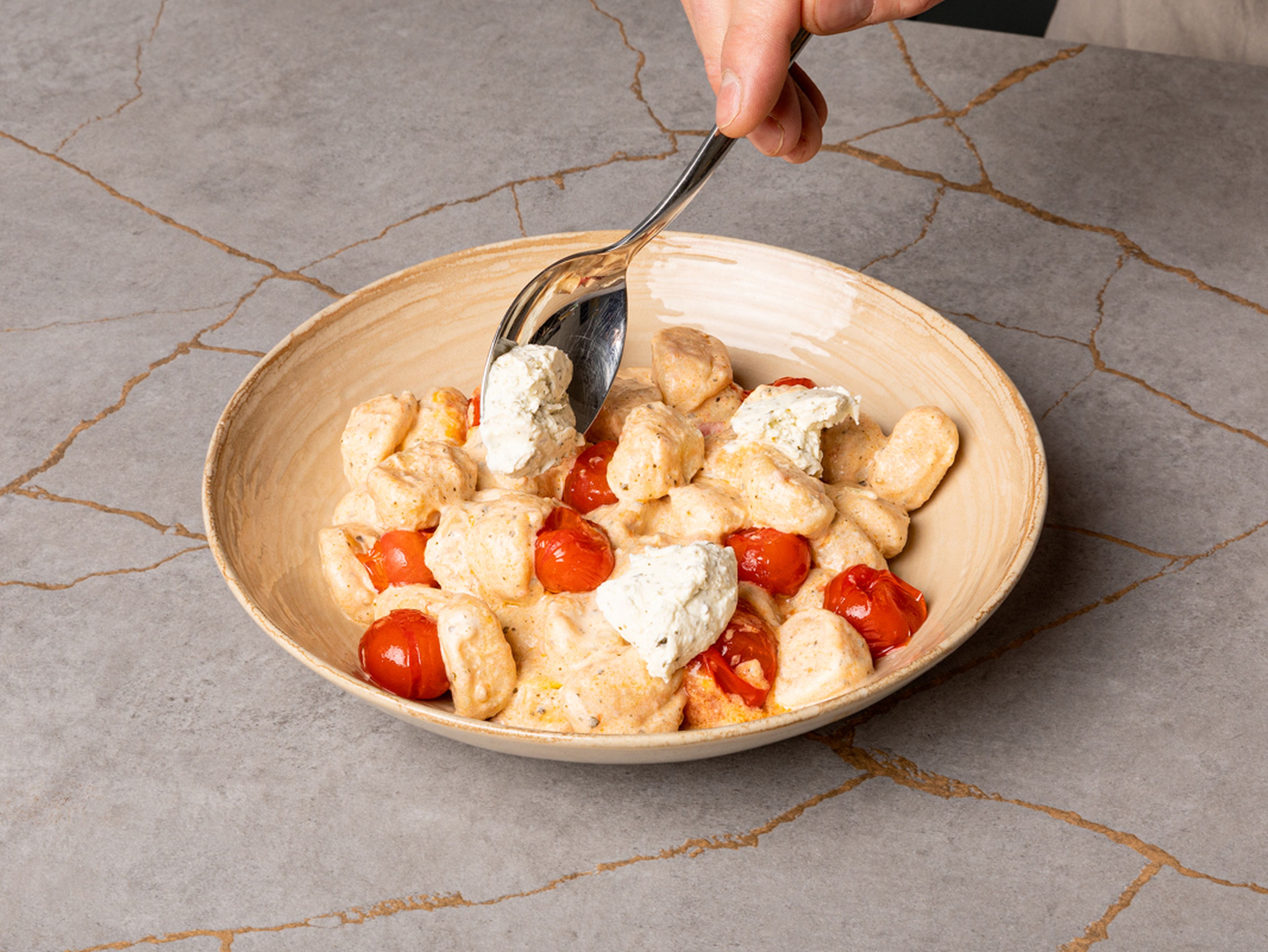 Gnocchi auf Tellern anrichten. Restlichen Kräuterfrischkäse in Flocken auf die Gnocchi verteilen, mit Frühlingszwiebelgrün bestreuen und optional mit frischem Basilikum garnieren. Guten Appetit!