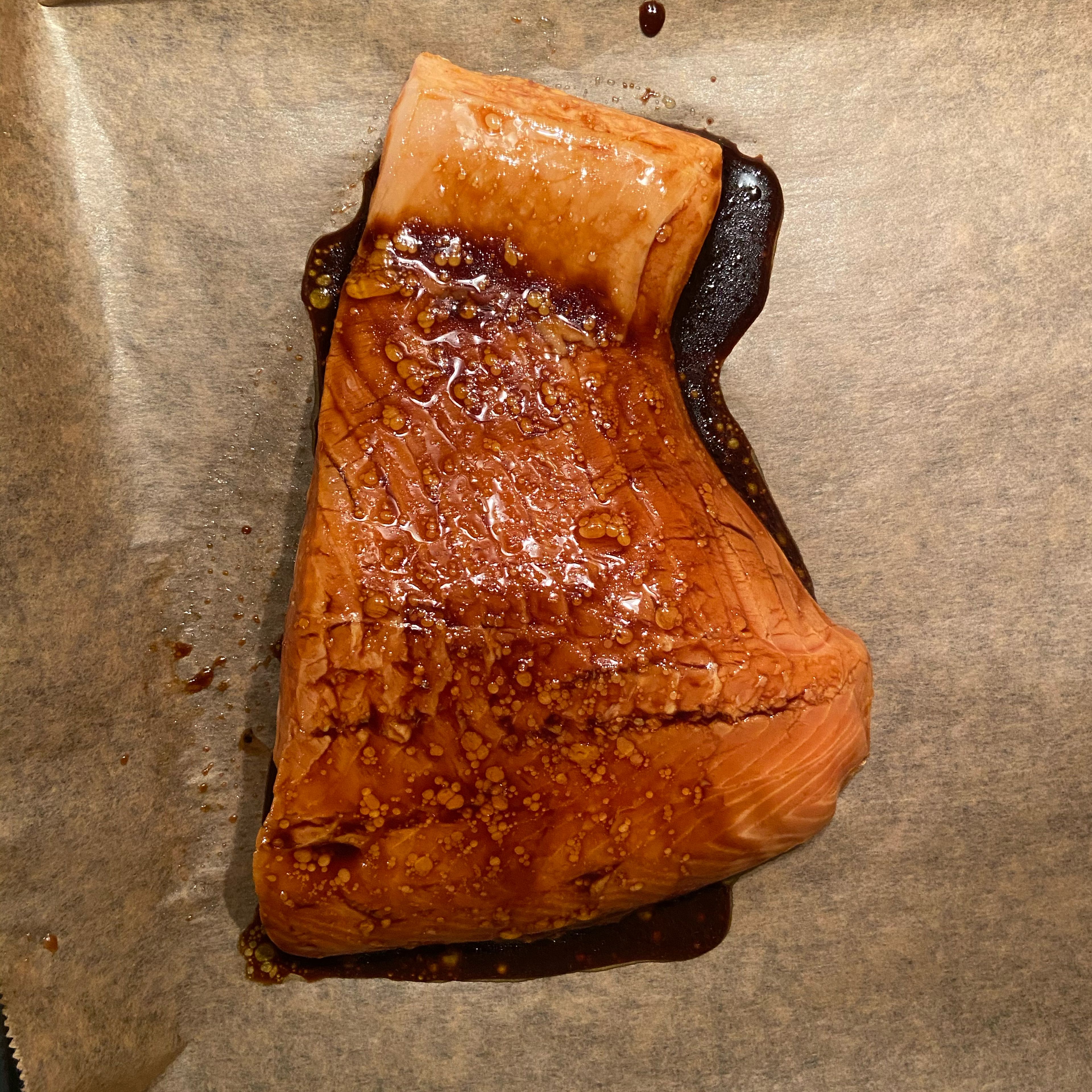 Mix soy sauce and apple cider vinegar in a bowl, add the salmon fillet and let it marinate for at least 10 minutes. Then place the salmon fillet on a baking sheet and cover it with the rest of the marinade sauce.