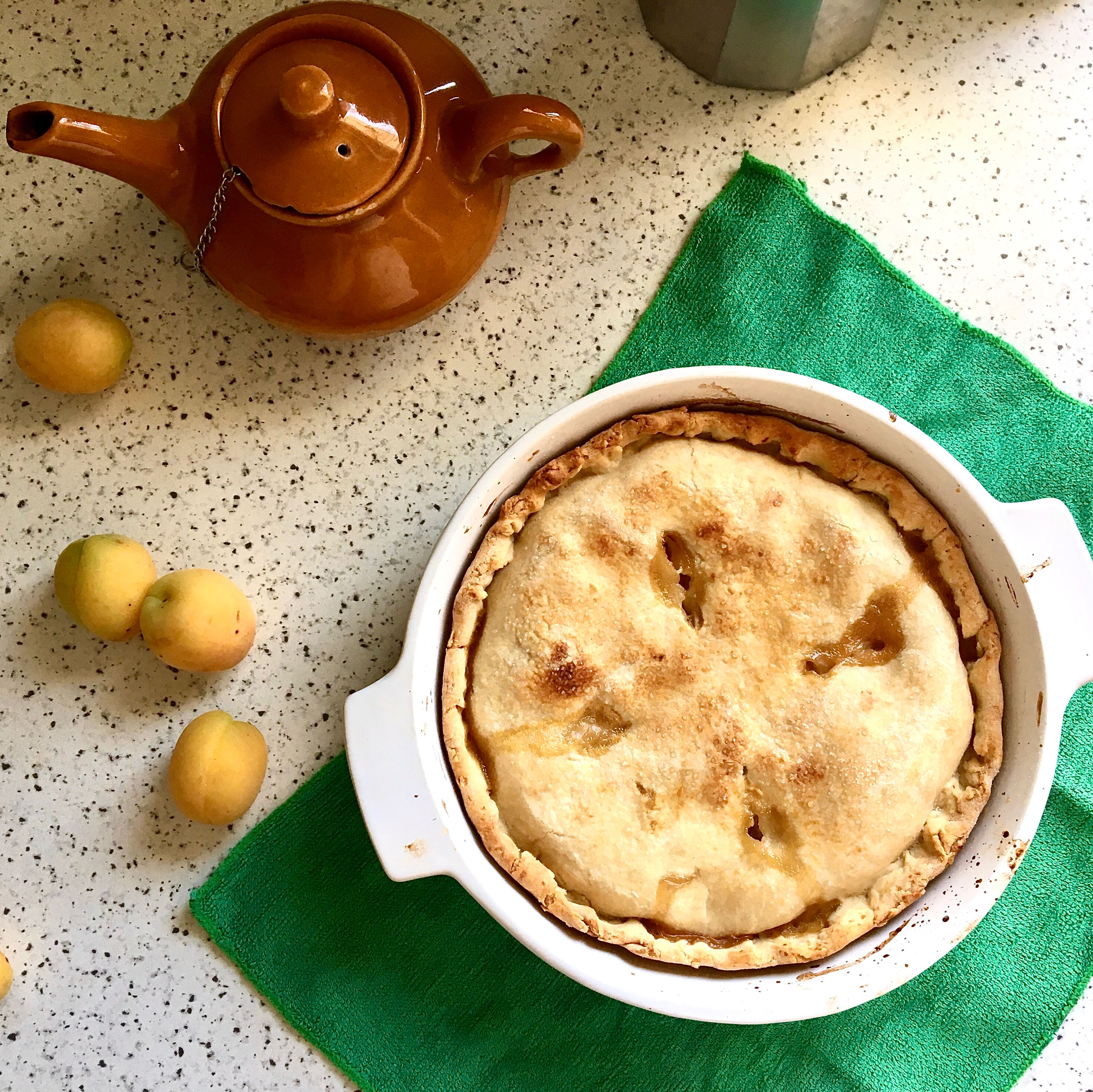 Using a pastry brush, brush the reserved apricot juice from the pan onto the pie. Cut some scores over the top and sprinkle with sugar. Bake at 180 C for 30-35 min. until the top is golden. Serve still warm with a cup of tea or a shot of espresso!