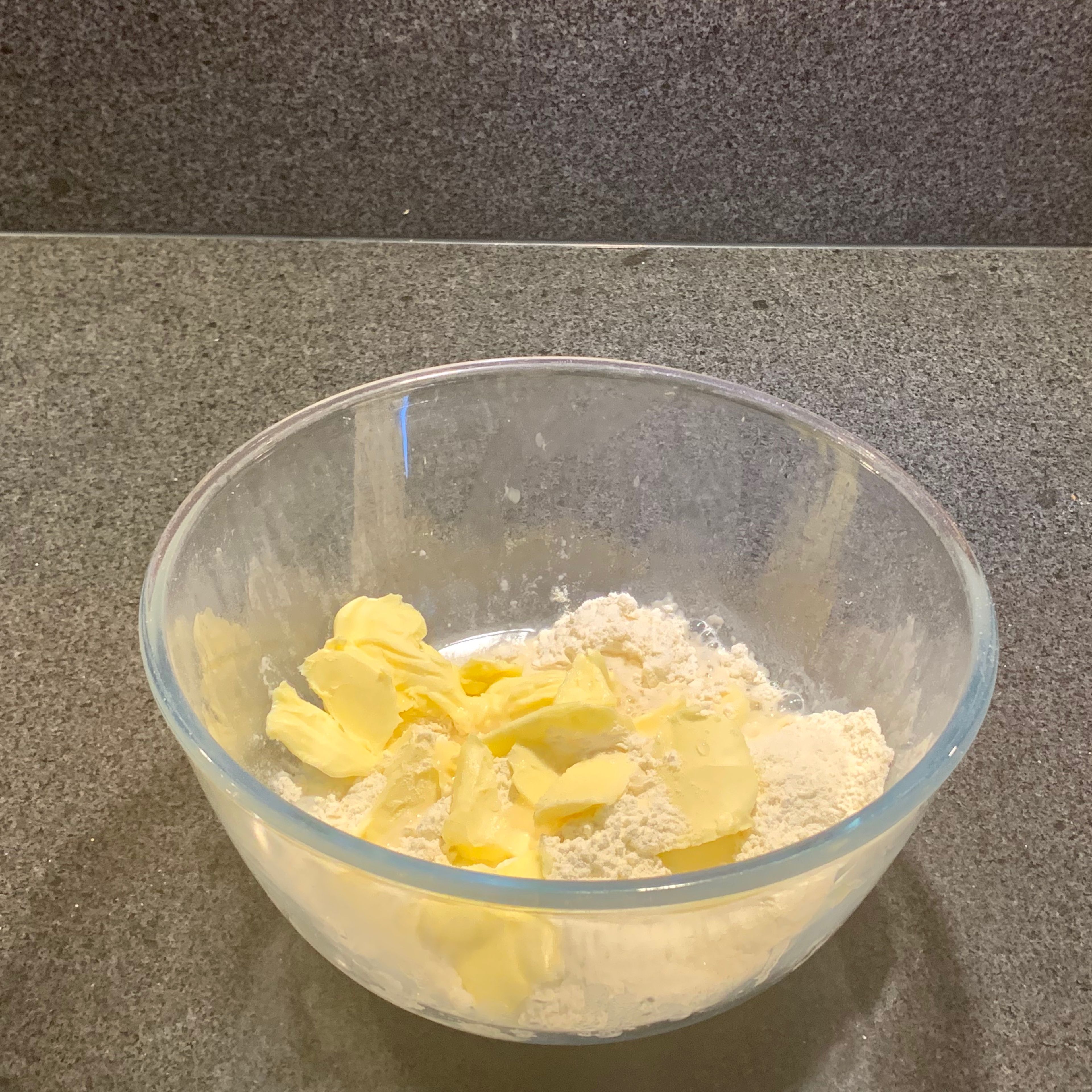 Das Mehl, die Butter in Flocken, Salz und das Wasser zuerst etwas zusammendrücken, dann kneten und so zu einem Teig verarbeiten. Allerdings nicht längere Zeit kneten.