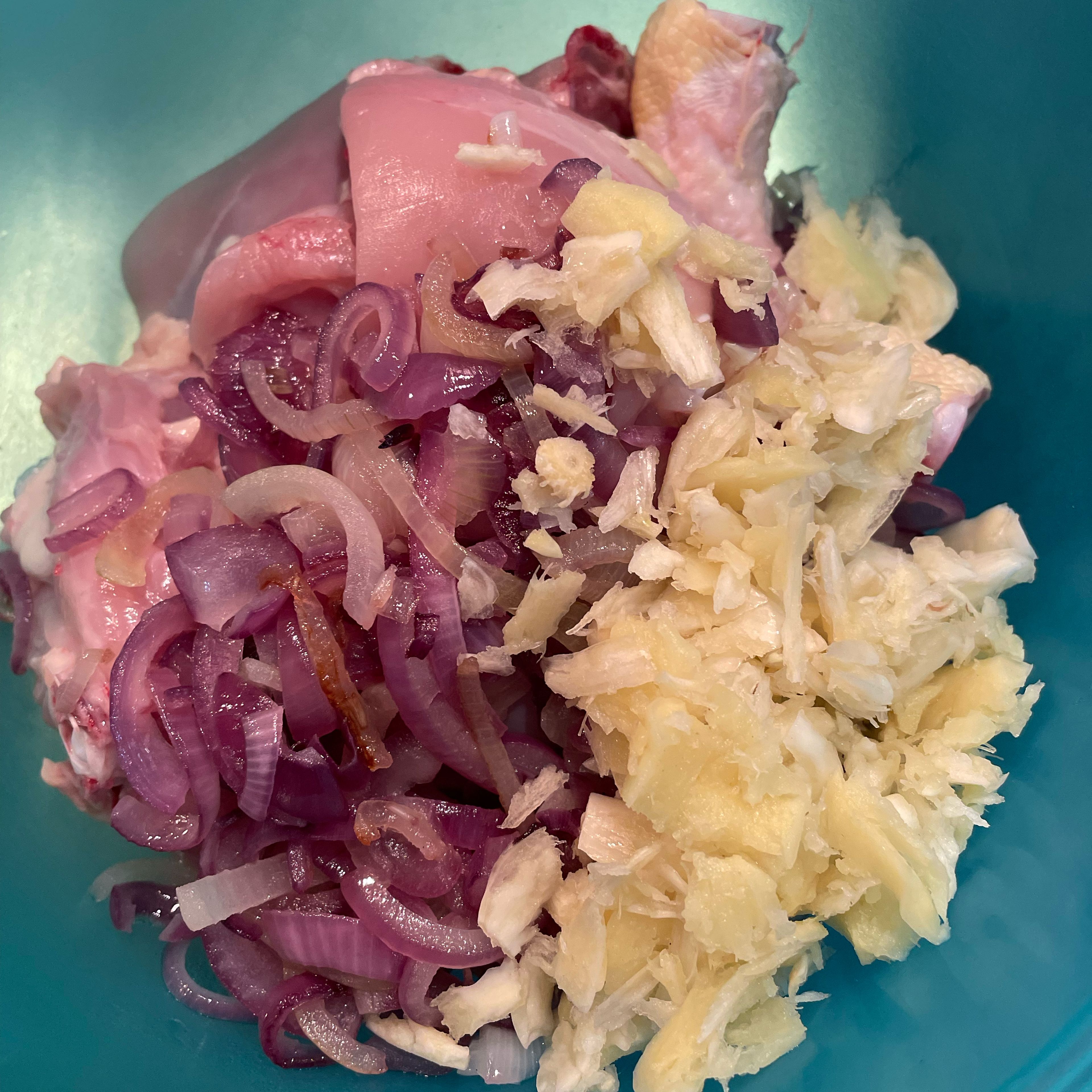 Slice onions and fry in coconut oil until golden brown. Remove from oil with a slotted spoon and place the fried onion on top of the chicken. Peel and mash ginger and garlic with a pestle. Place on top of chicken.