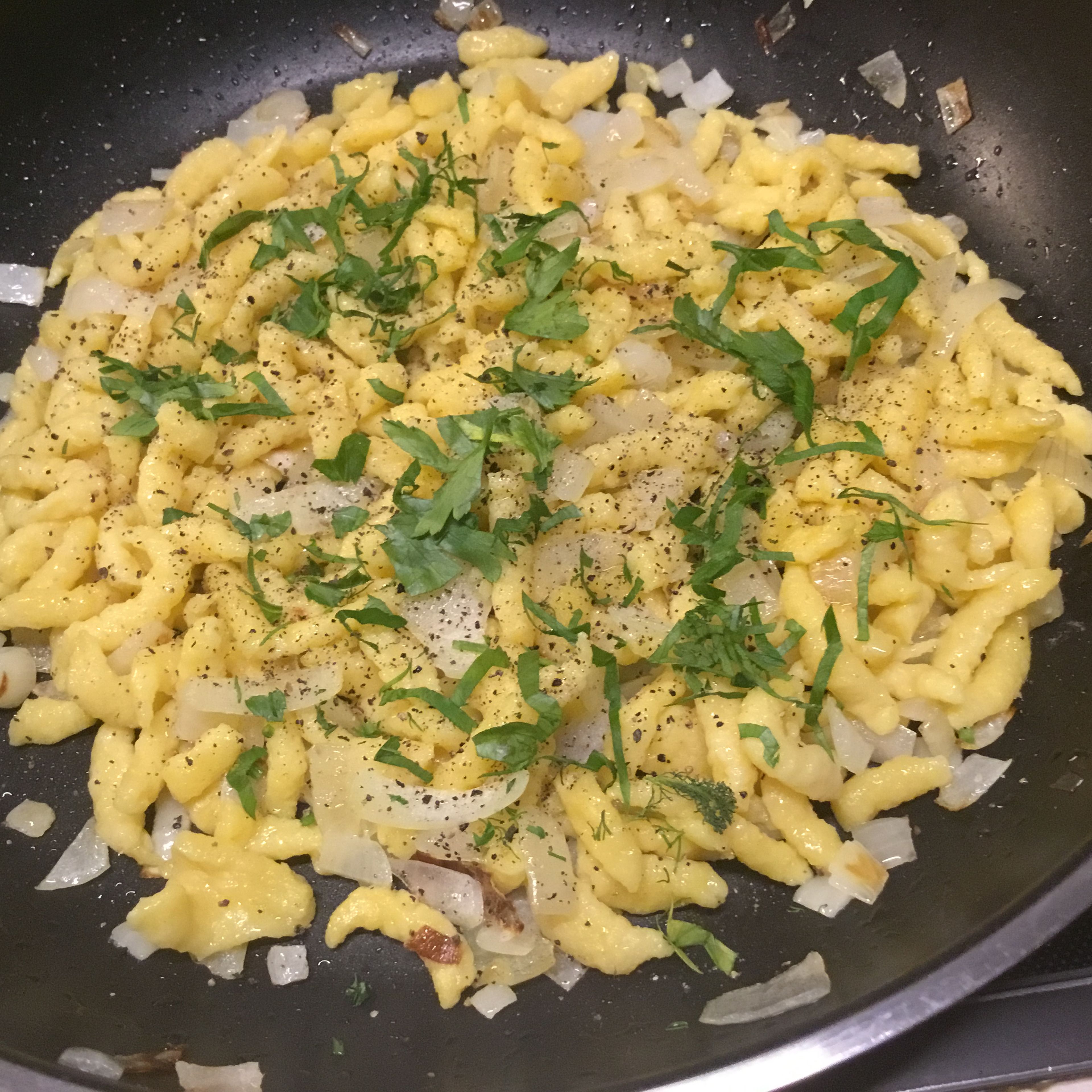 Zwiebeln und Fertigspätzle sollen etwas Farbe kommen. Dazwischen wenig salzen und pfeffern und fein geschnittene Petersilie drüber streuen.