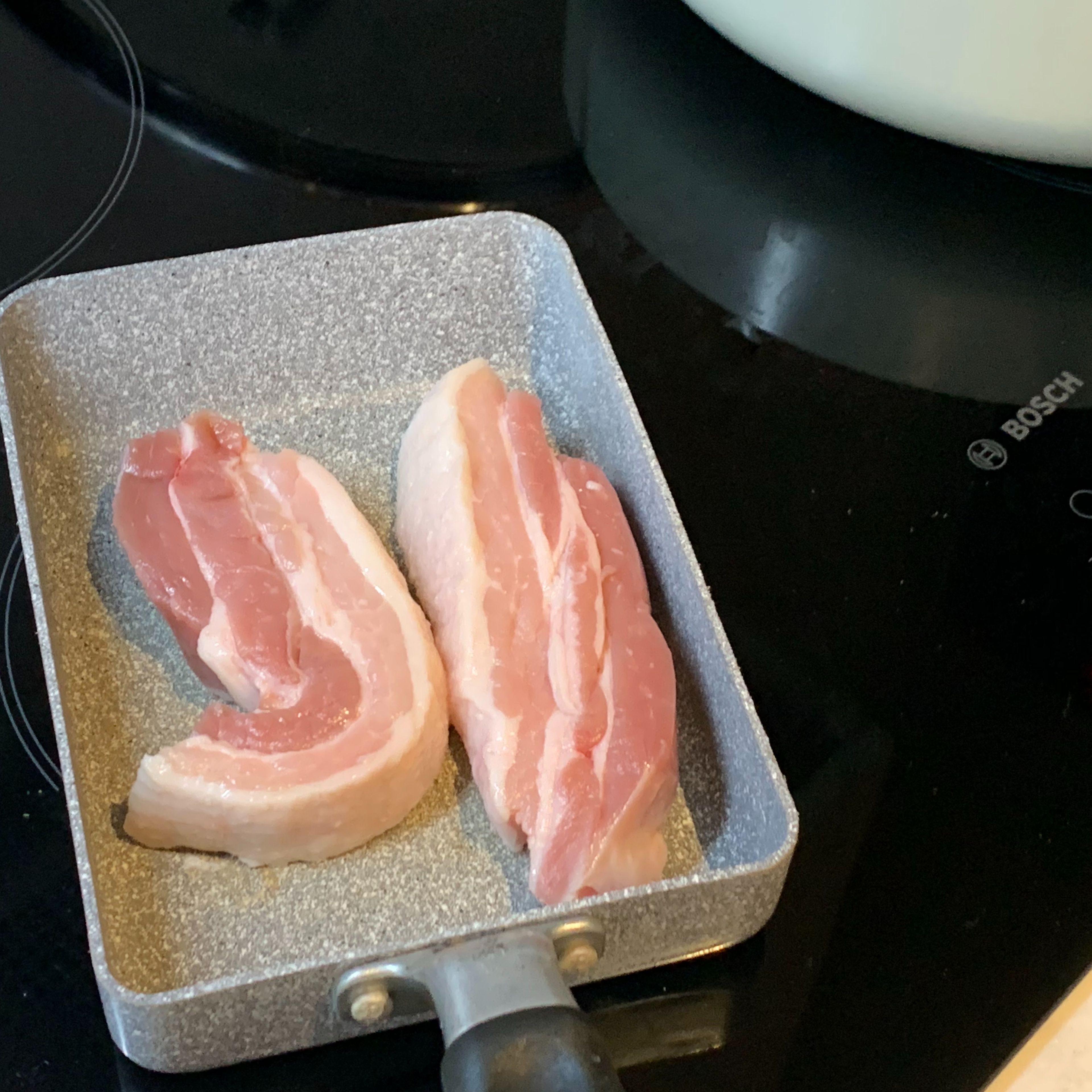 Place the pork belly slices onto a heated frying pan without oil.