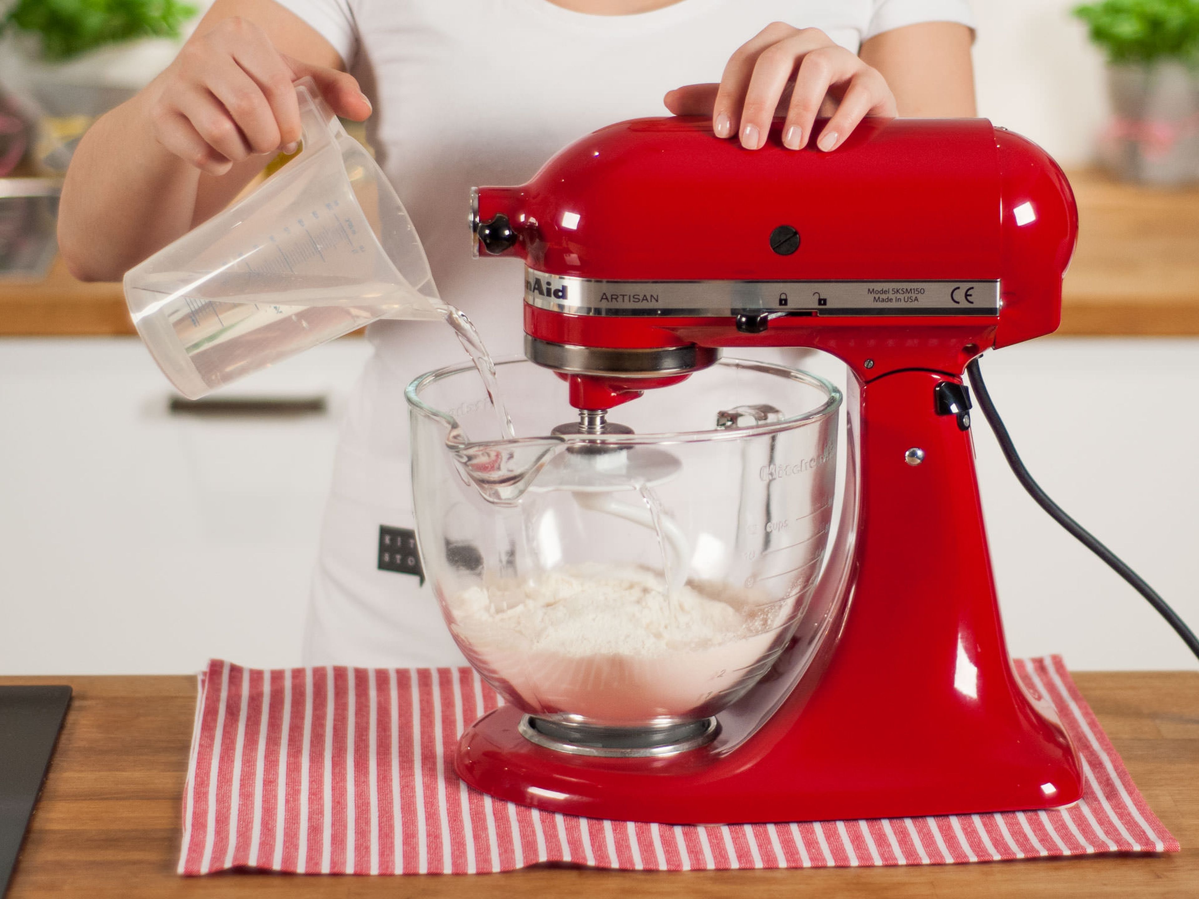 Mehl in die Küchenmaschine geben. Mit einem Teil des Wassers und einer Prise Salz ca. 5 - 7 Min. mischen und kneten, bis sich ein glatter Teig bildet.